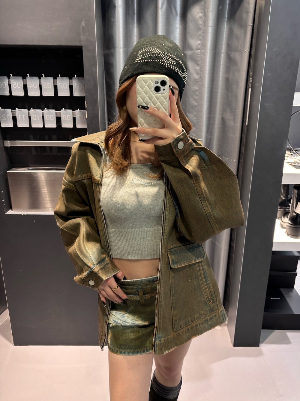 グレー系のニット/セーター、ブラウン系のブルゾン、ブラウン系のスカートを着用したレディースの冬コーディネートの4枚目の写真