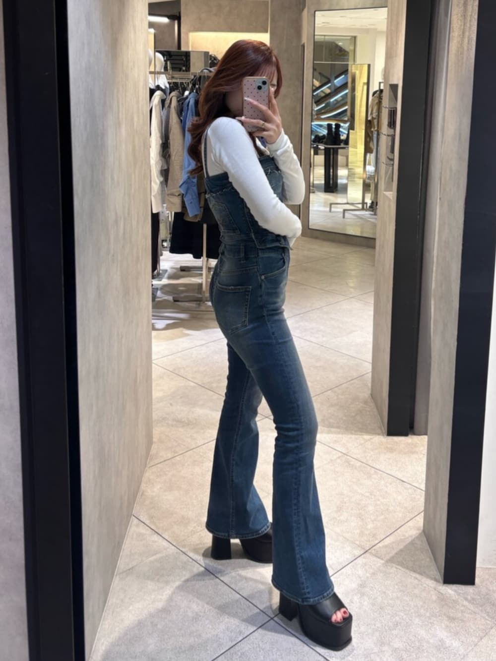 ホワイト系のTシャツ/カットソー、ブルー系のサロペット/オーバーオール、ブラック系のサンダルを着用したレディースの春コーディネートの2枚目の写真