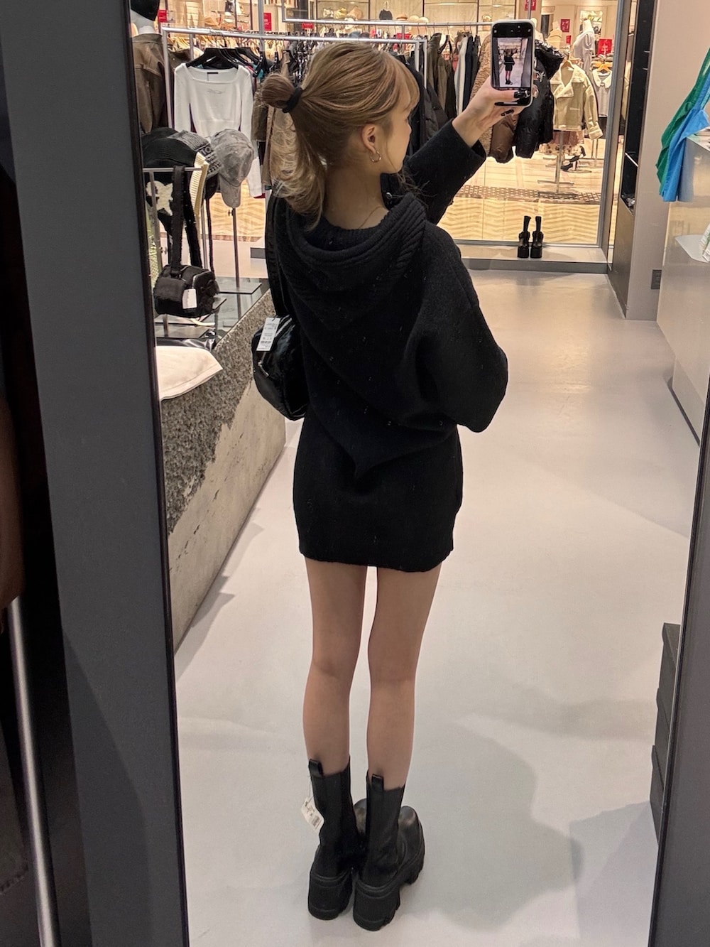 ブラック系のニット/セーター、ブラック系のボストンバッグ、ブラック系のブーツを着用したレディースの冬コーディネートの3枚目の写真