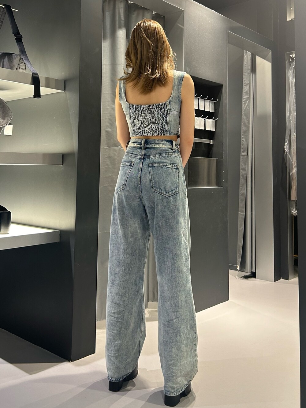 ブルー系のキャミソール、ブルー系のデニムパンツ、ブラック系のサンダルを着用したレディースの夏コーディネートの4枚目の写真