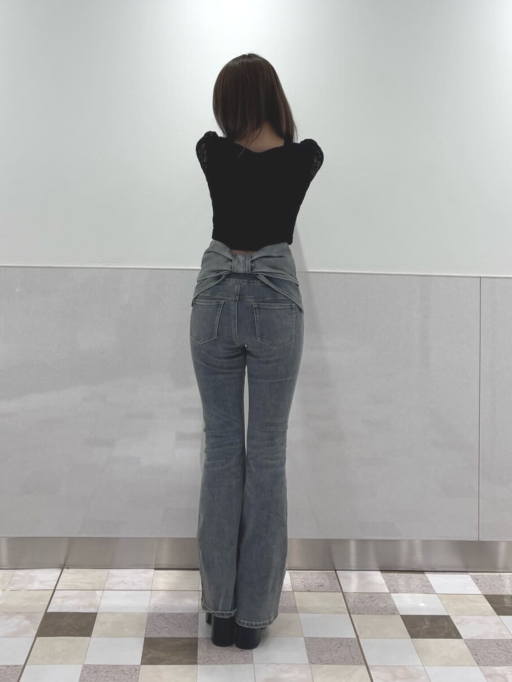 ブラック系のその他シューズ、ブラック系のTシャツ/カットソー、ブルー系のデニムパンツを着用したレディースの秋コーディネートの3枚目の写真