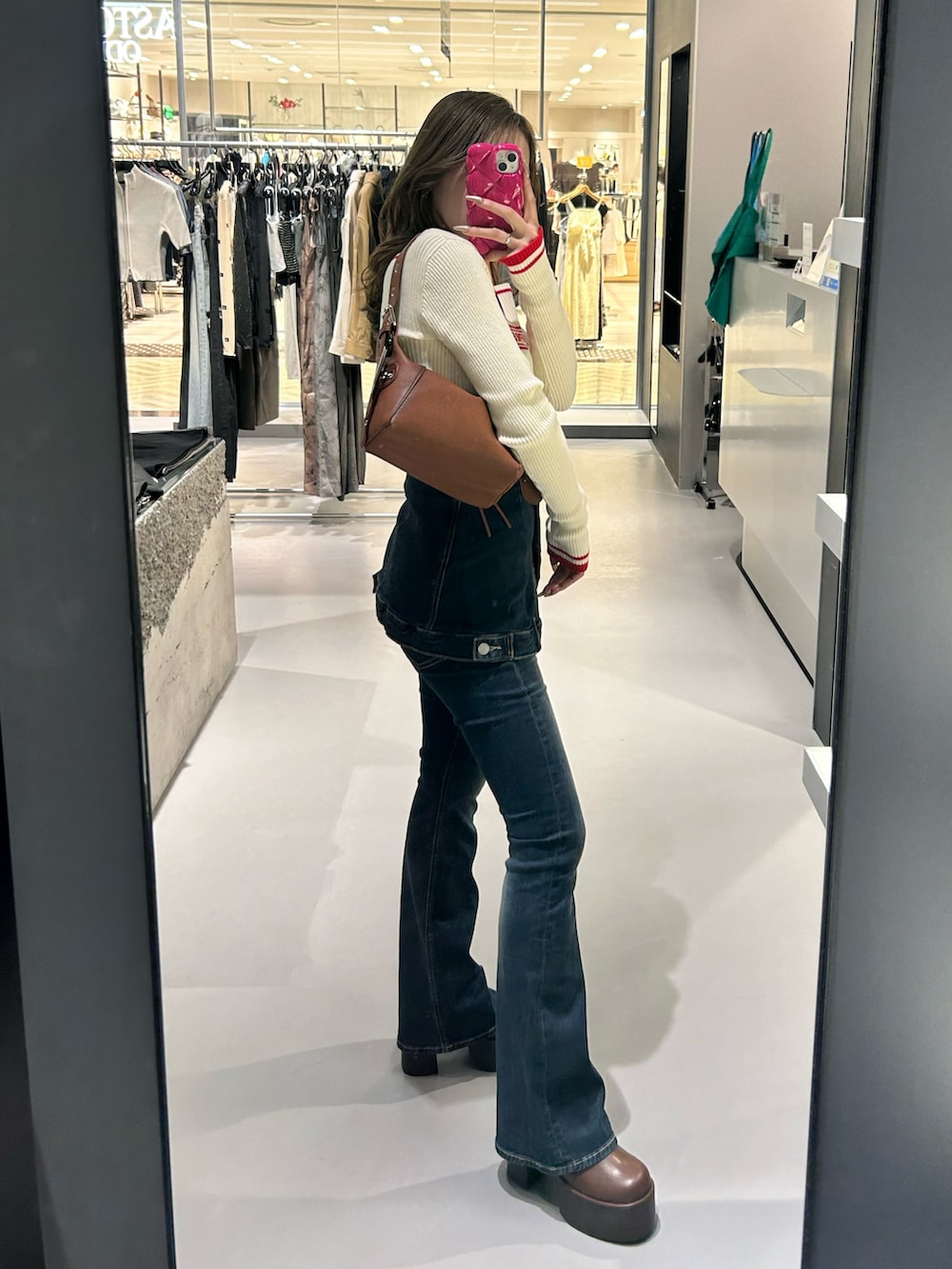 ホワイト系のニット/セーター、ブルー系のデニムパンツ、ブラウン系のブーツを着用したレディースの秋コーディネートの2枚目の写真