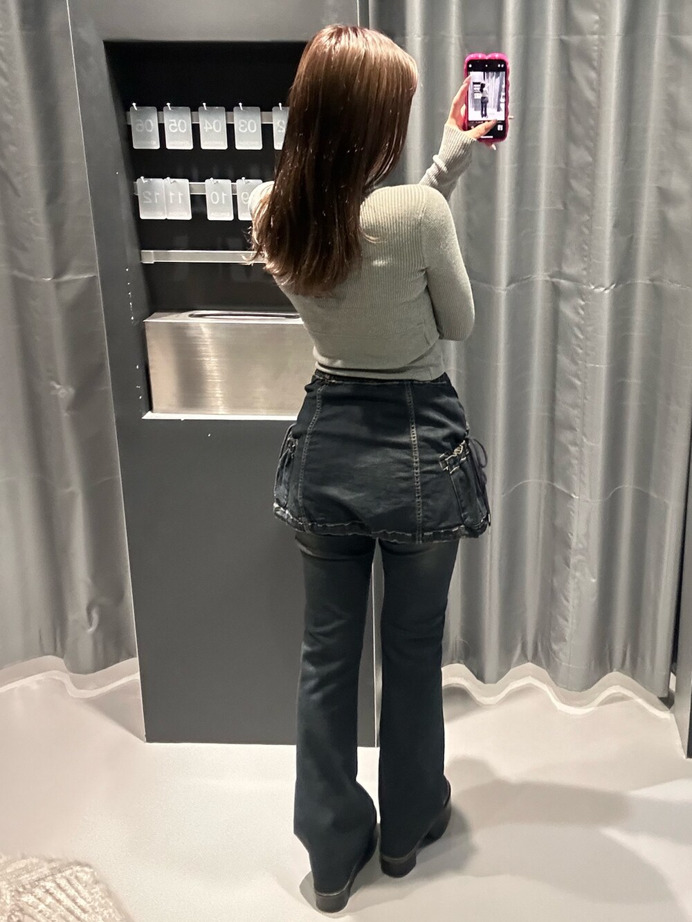 グレー系のニット/セーター、ブルー系のデニムパンツ、ブラック系のブーツを着用したレディースの秋コーディネートの3枚目の写真