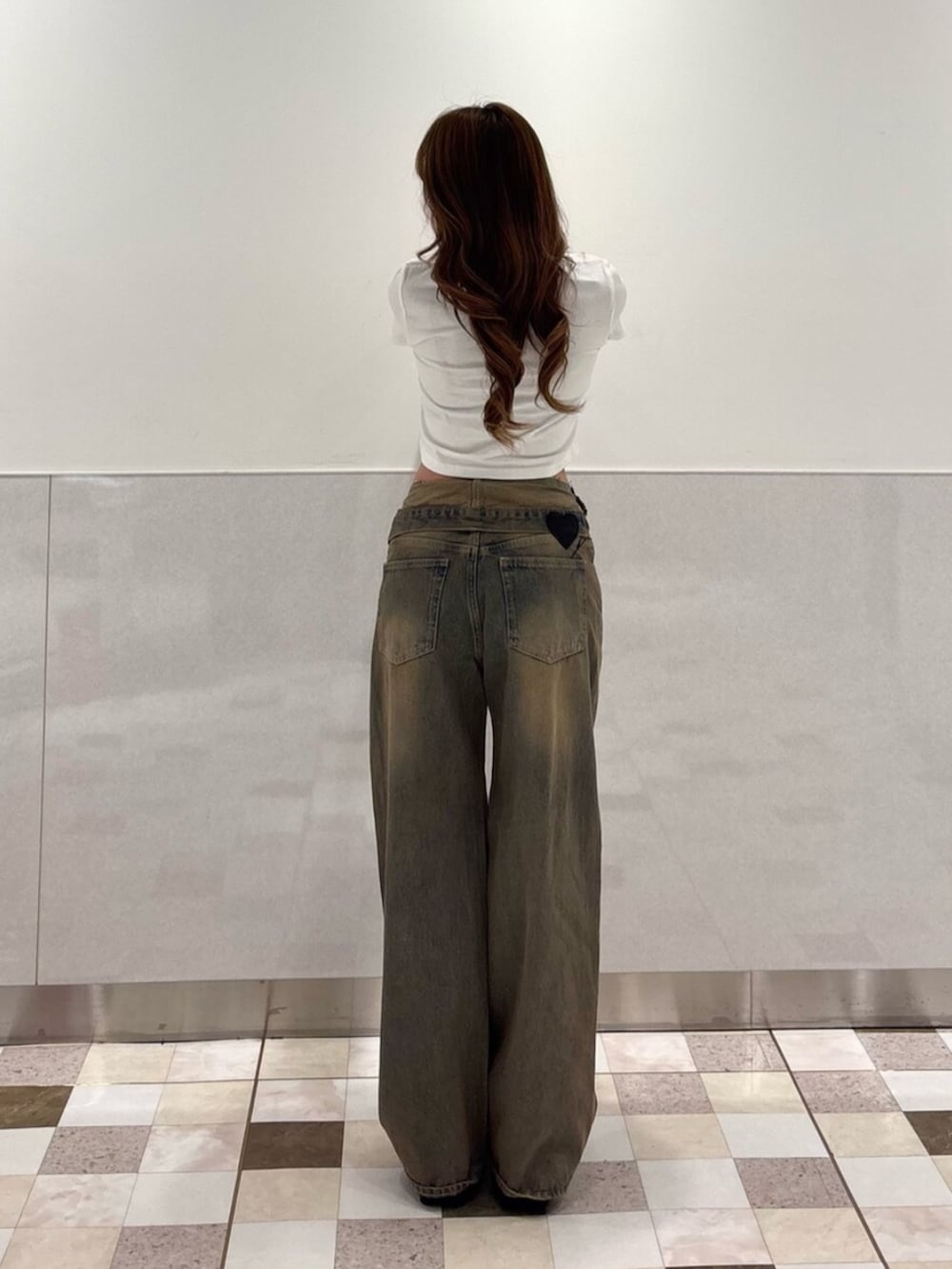 ブラック系のサンダル、ホワイト系のTシャツ/カットソー、ブラウン系のデニムパンツを着用したレディースの夏コーディネートの3枚目の写真