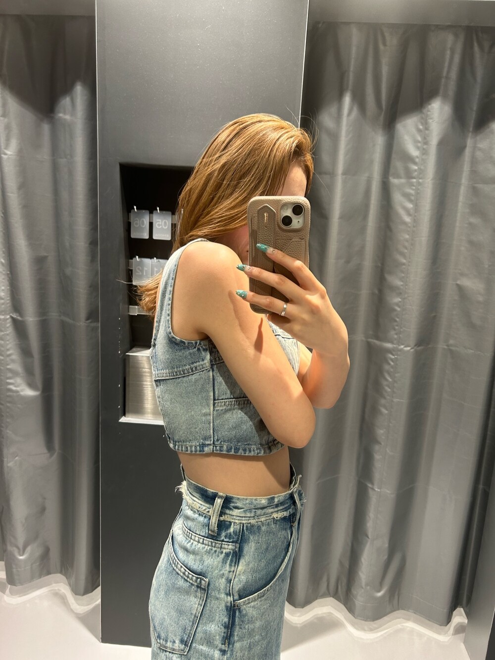 ブルー系のキャミソール、ブルー系のデニムパンツ、ブラック系のサンダルを着用したレディースの夏コーディネートの2枚目の写真