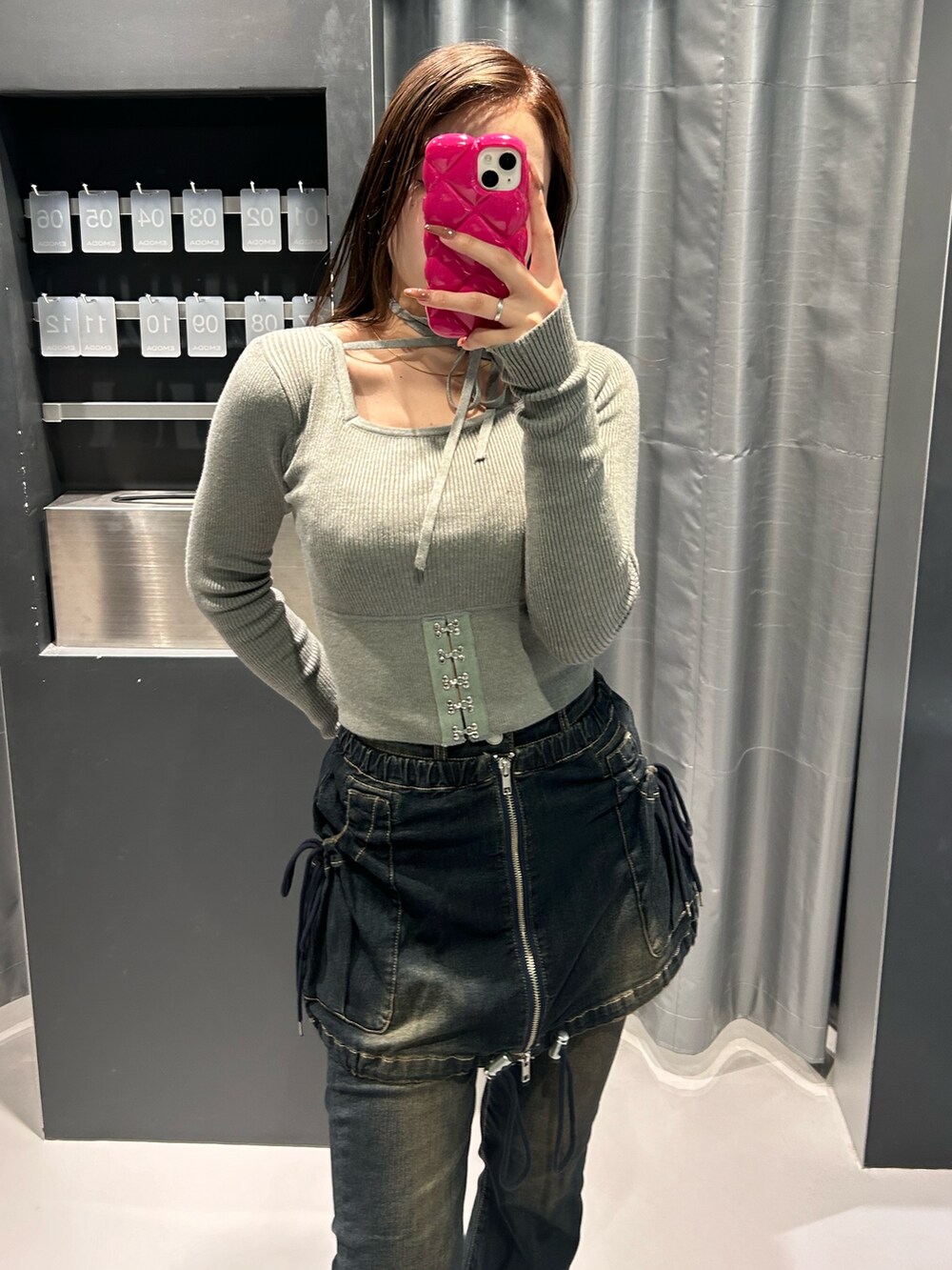 グレー系のニット/セーター、ブルー系のデニムパンツ、ブラック系のブーツを着用したレディースの秋コーディネートの4枚目の写真