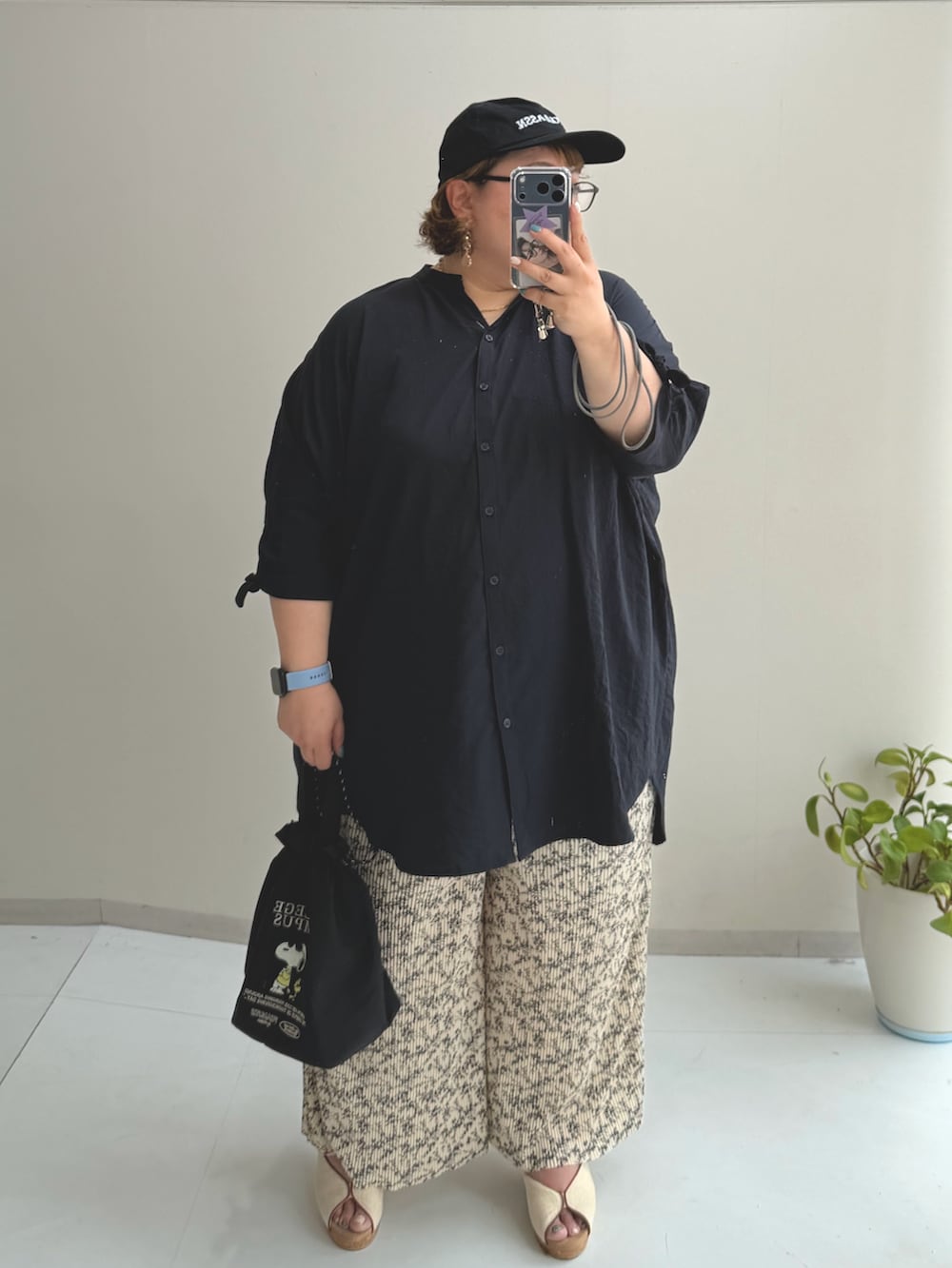 ブラック系のパンツ、ブラック系のトートバッグ、ブルー系のシャツ/ブラウスを着用したレディースの夏コーディネートの2枚目の写真