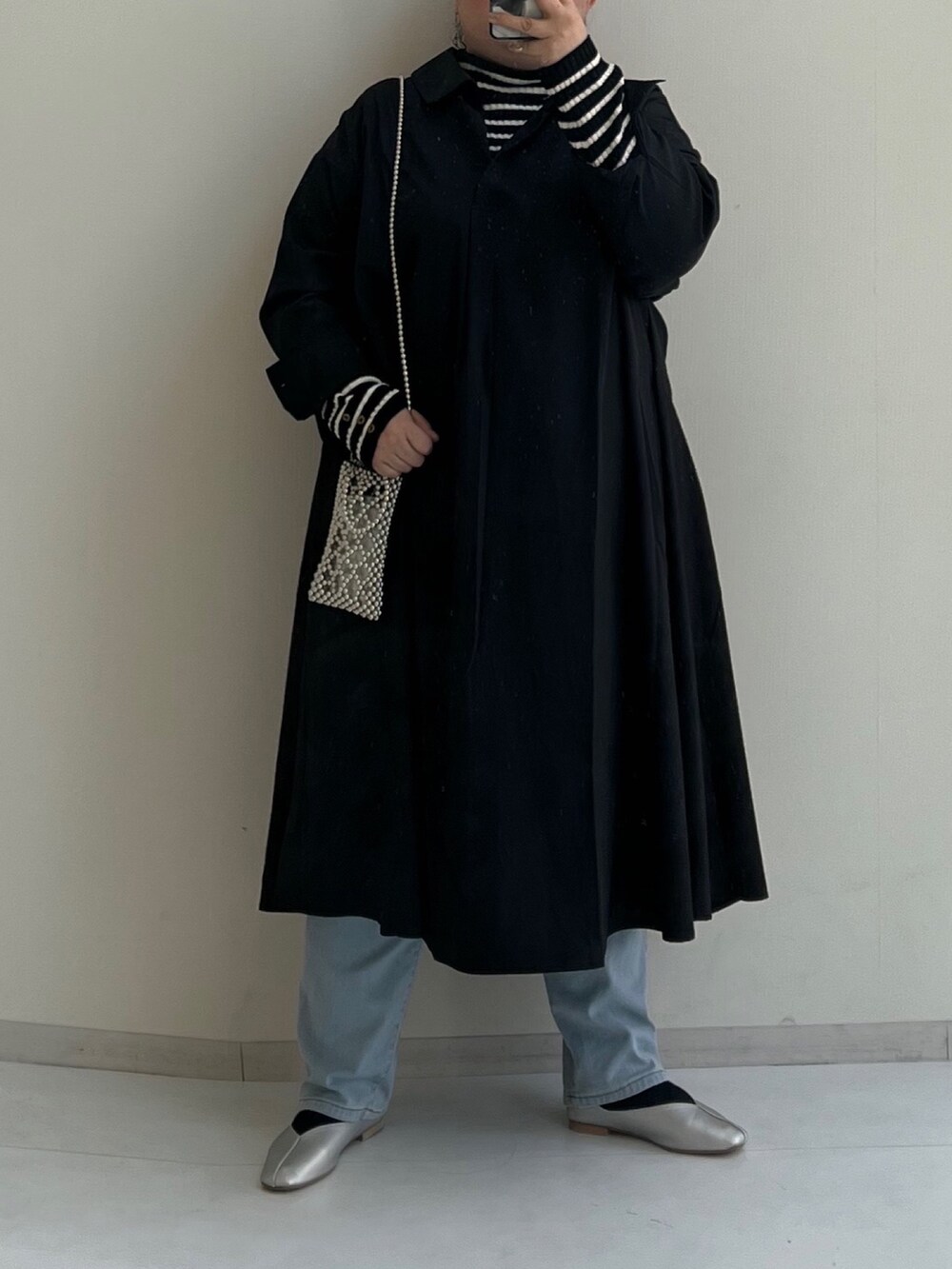 ブラック系のワンピース、ブラック系のニット/セーター、ブルー系のパンツを着用したレディースの冬コーディネートの2枚目の写真