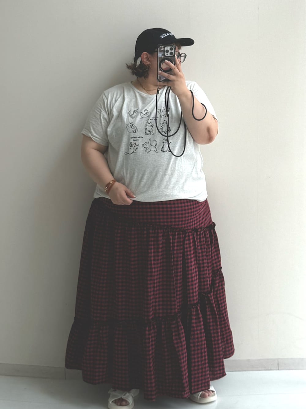 ホワイト系のサンダル、ブラック系のスカート、グレー系のTシャツ/カットソーを着用したレディースの夏コーディネートの2枚目の写真