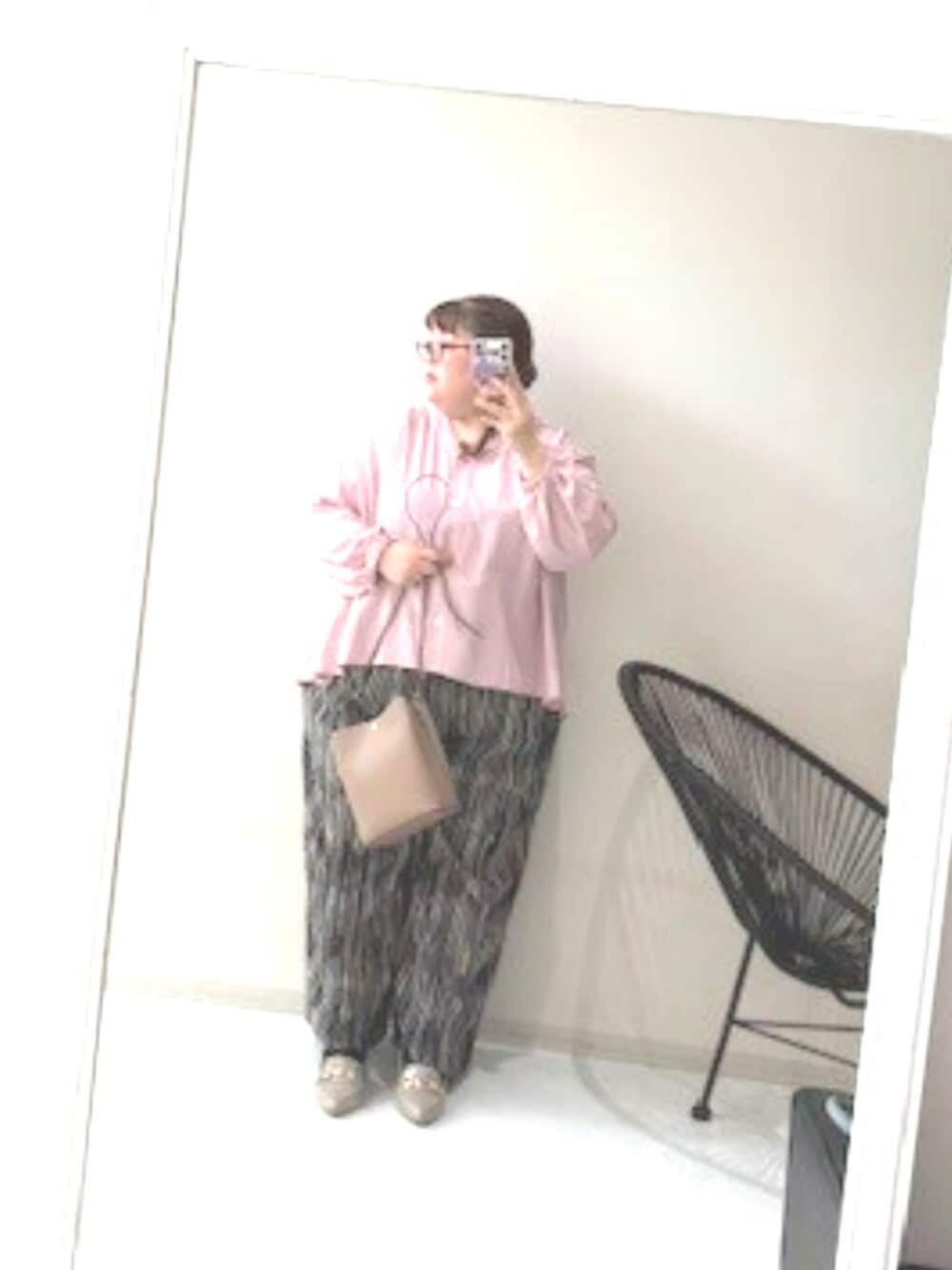 ピンク系のシャツ/ブラウス、ブラック系のパンツ、グレー系のショルダーバッグを着用したレディースの冬コーディネートの2枚目の写真