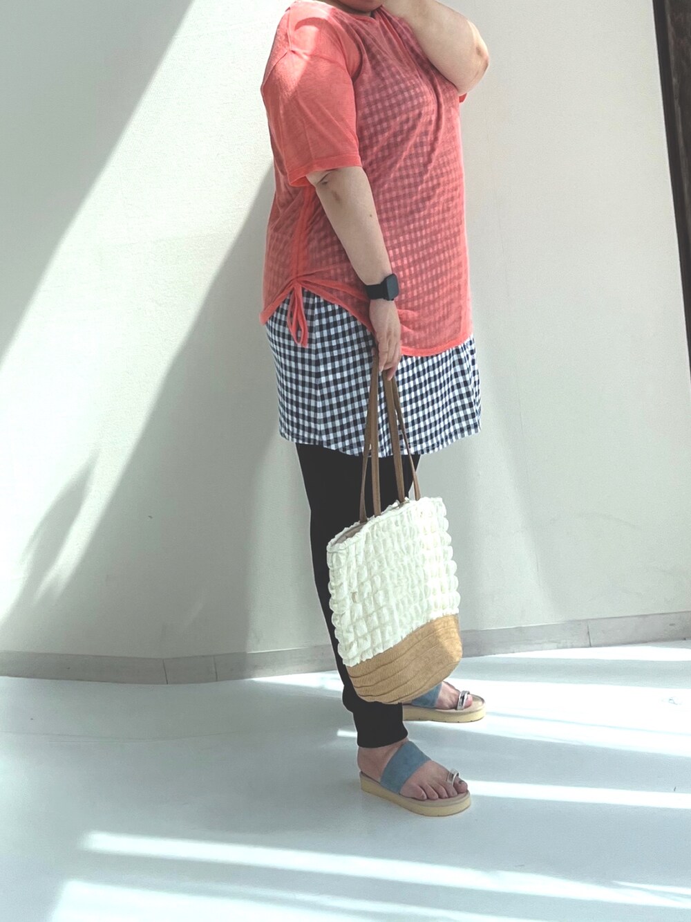 オレンジ系のチュニック、ホワイト系のトートバッグ、ブルー系のサンダルを着用したレディースの夏コーディネートの2枚目の写真