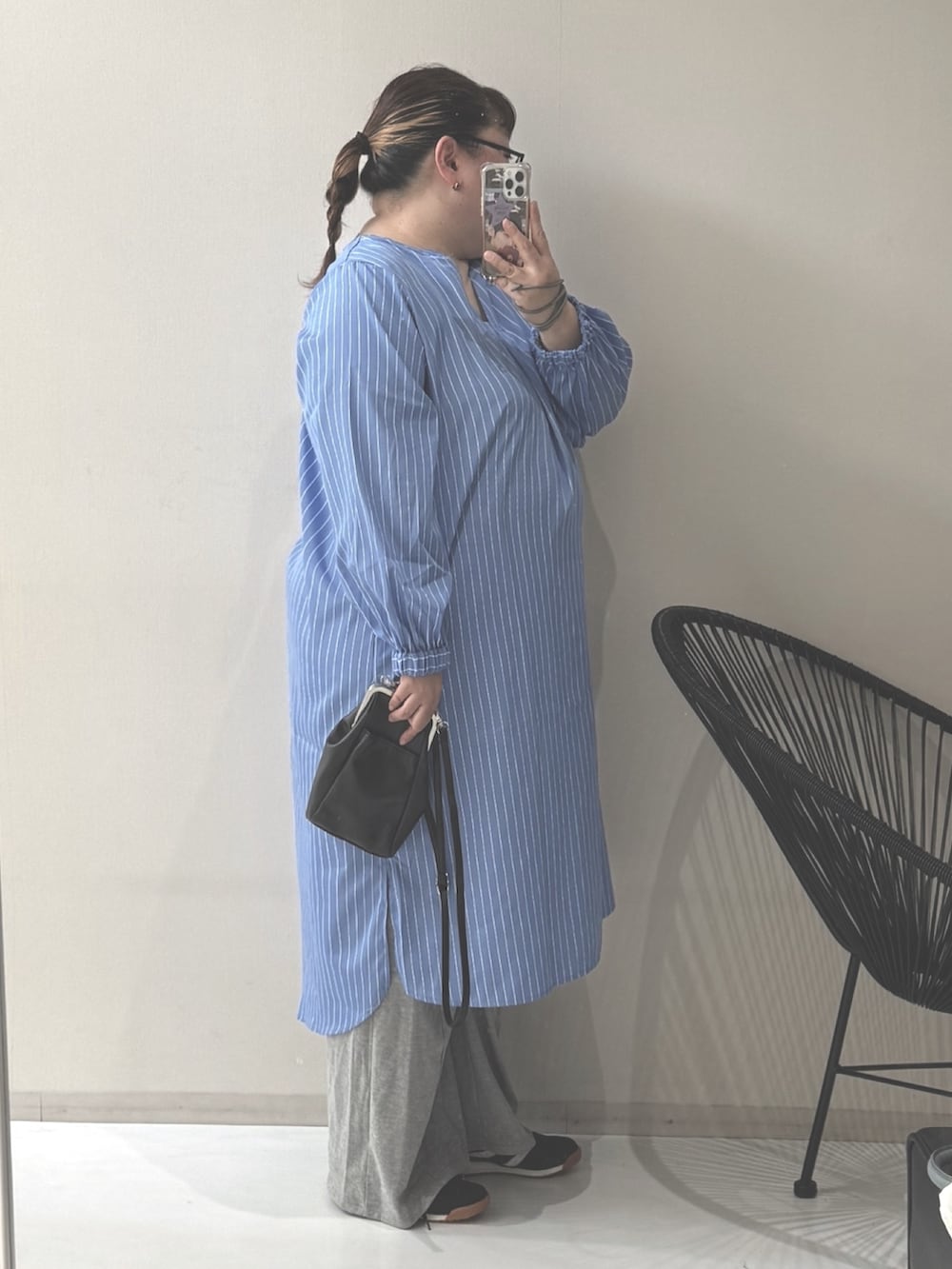 ブルー系のワンピース、グレー系のパンツ、ブラック系のショルダーバッグを着用したレディースの冬コーディネートの2枚目の写真