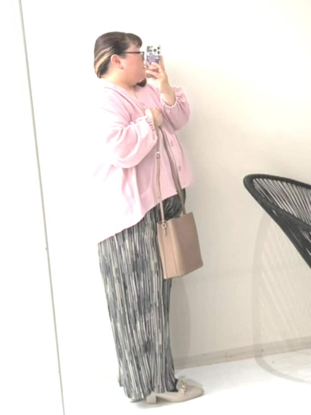 ピンク系のシャツ/ブラウス、ブラック系のパンツ、グレー系のショルダーバッグを着用したレディースの冬コーディネートの3枚目の写真