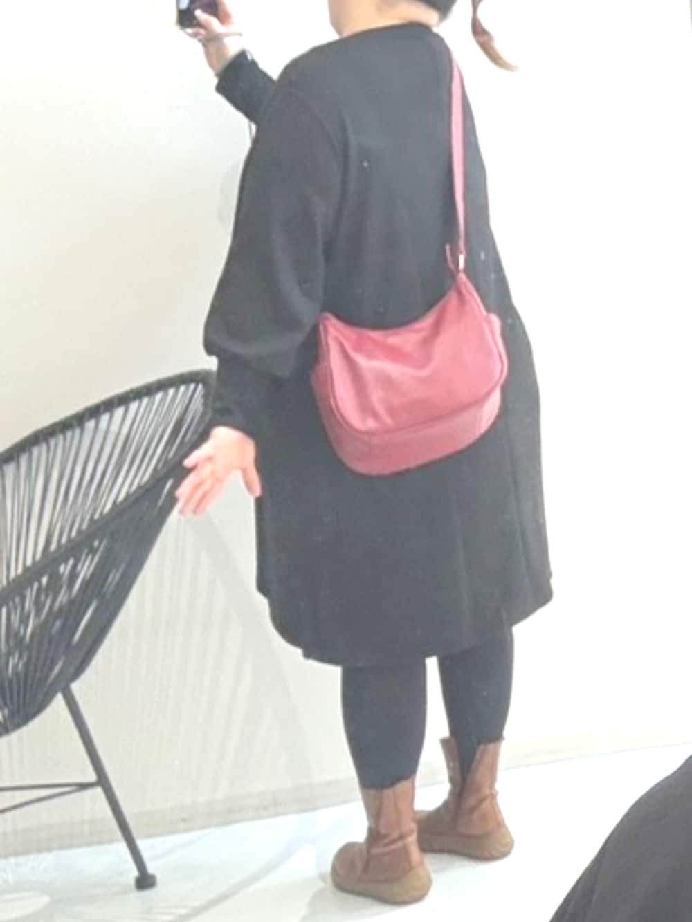 ブラック系のチュニック、レッド系のショルダーバッグを着用したレディースの冬コーディネートの3枚目の写真