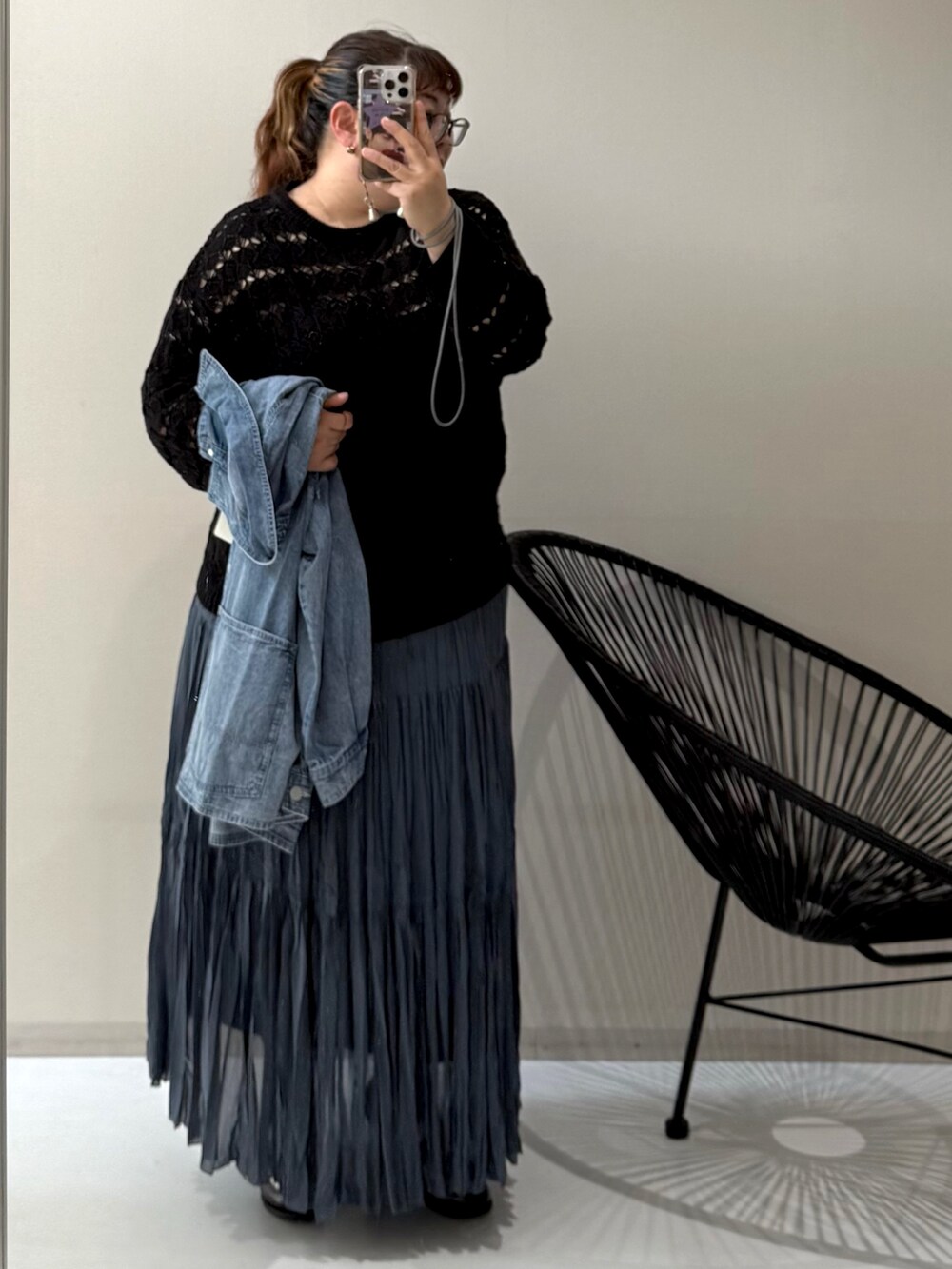 ブラック系のスニーカー、ブルー系のジャケット/アウター、ブラック系のニット/セーターを着用したレディースの冬コーディネートの2枚目の写真