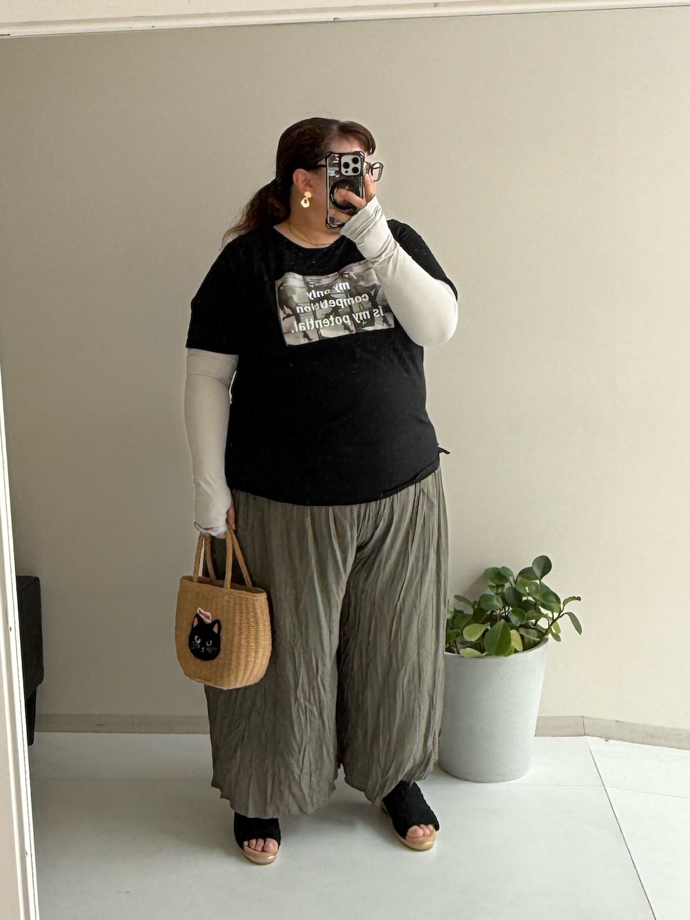 ブラウン系のパンツ、ブラック系のサンダル、ベージュ系のトートバッグを着用したレディースの春コーディネートの2枚目の写真