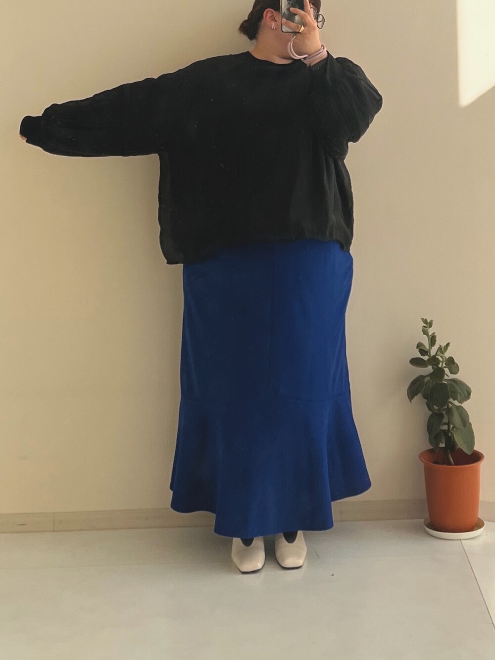 ブラック系のTシャツ/カットソー、ブルー系のスカート、ホワイト系のパンプスを着用したレディースの冬コーディネートの2枚目の写真