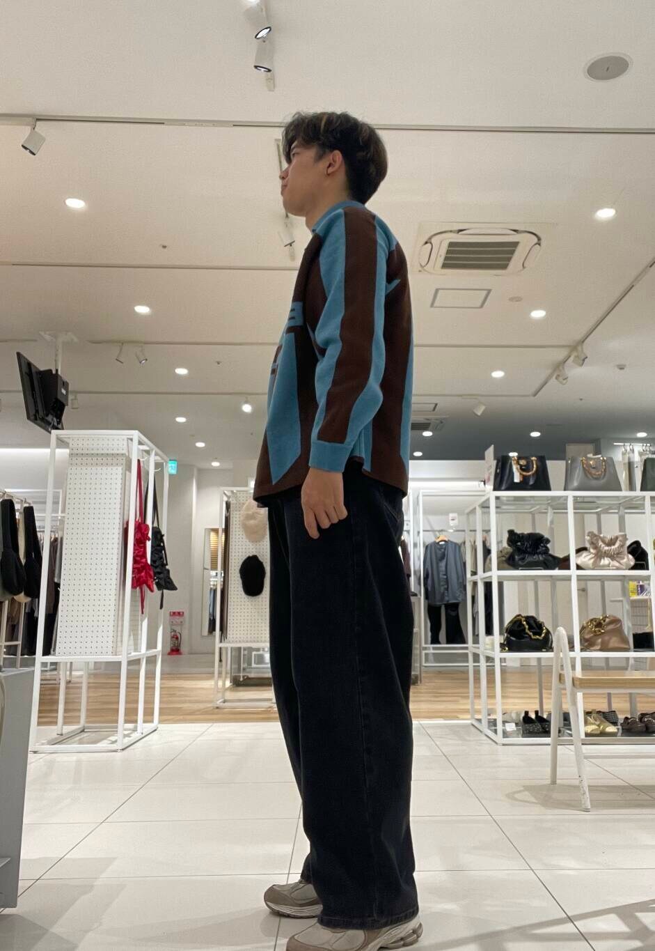 ブラック系のデニムパンツ、ブルー系のニット/セーターを着用したメンズの秋コーディネートの2枚目の写真