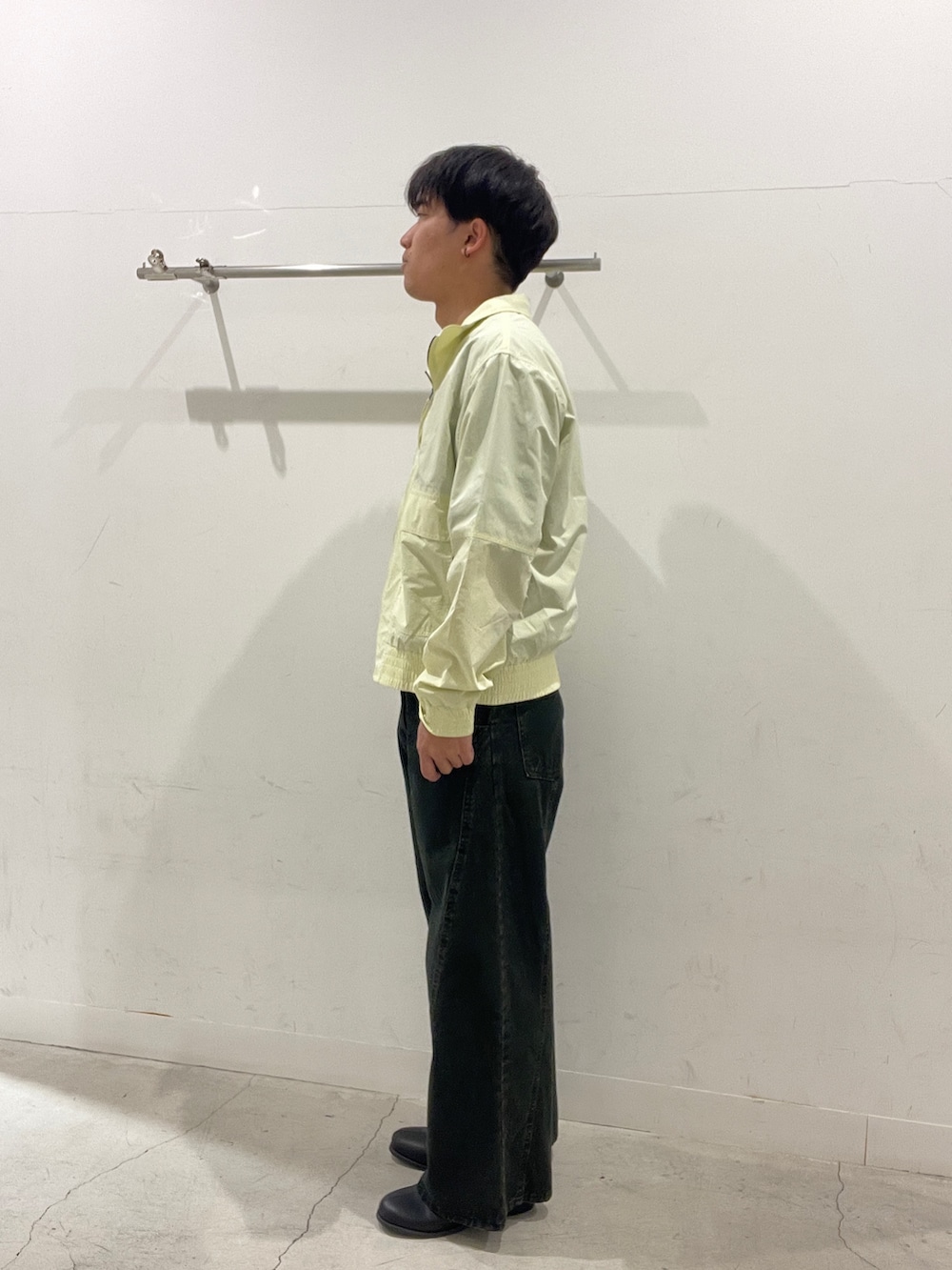 イエロー系のブルゾン、ブルー系のスウェット、ブラック系のデニムパンツを着用したメンズの春コーディネートの2枚目の写真