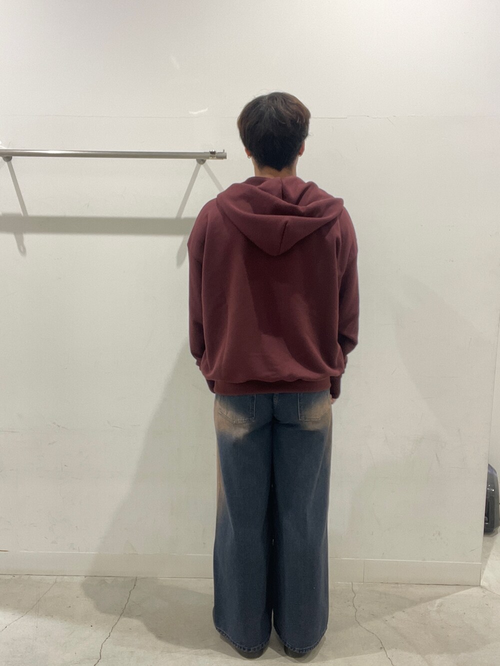 ブルー系のデニムパンツ、ブラック系のローファー、レッド系のパーカーを着用したメンズの秋コーディネートの3枚目の写真