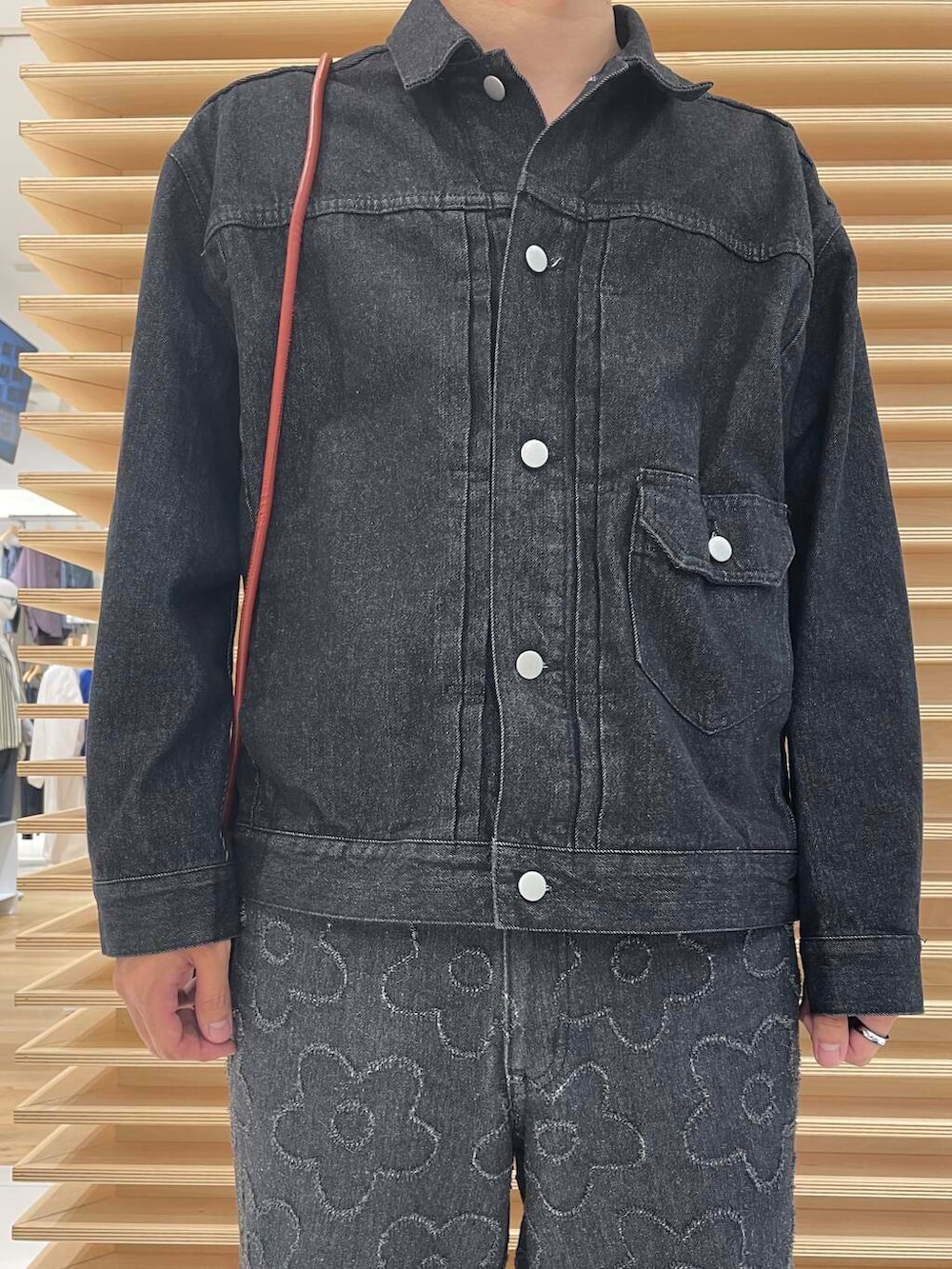 ブラック系のデニムパンツ、ブラック系のデニムジャケット、オレンジ系のショルダーバッグを着用したメンズの秋コーディネートの4枚目の写真