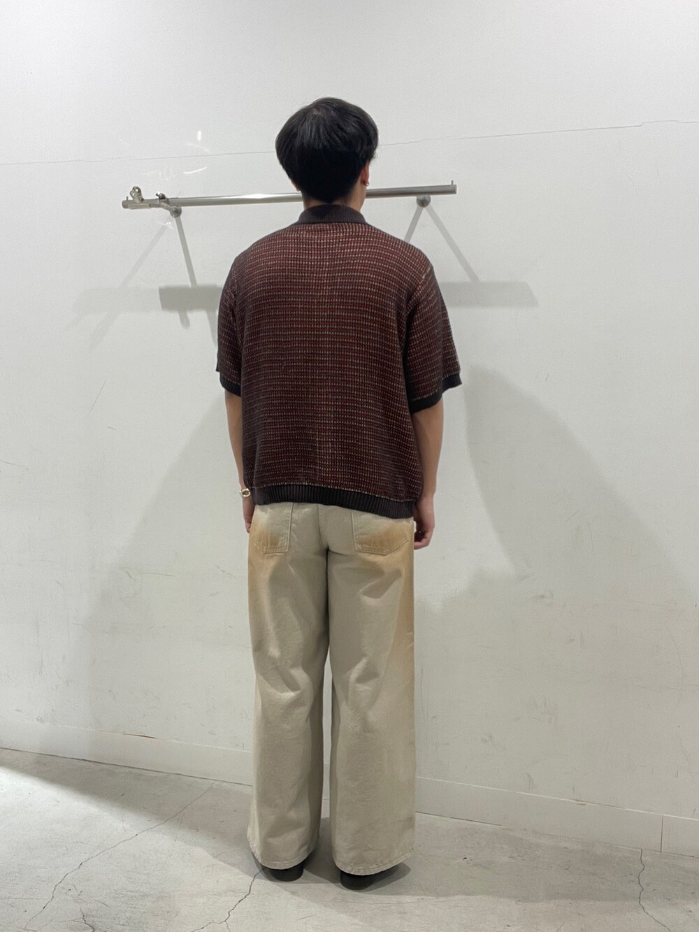 レッド系のニット/セーター、グリーン系のデニムパンツを着用したメンズの春コーディネートの3枚目の写真