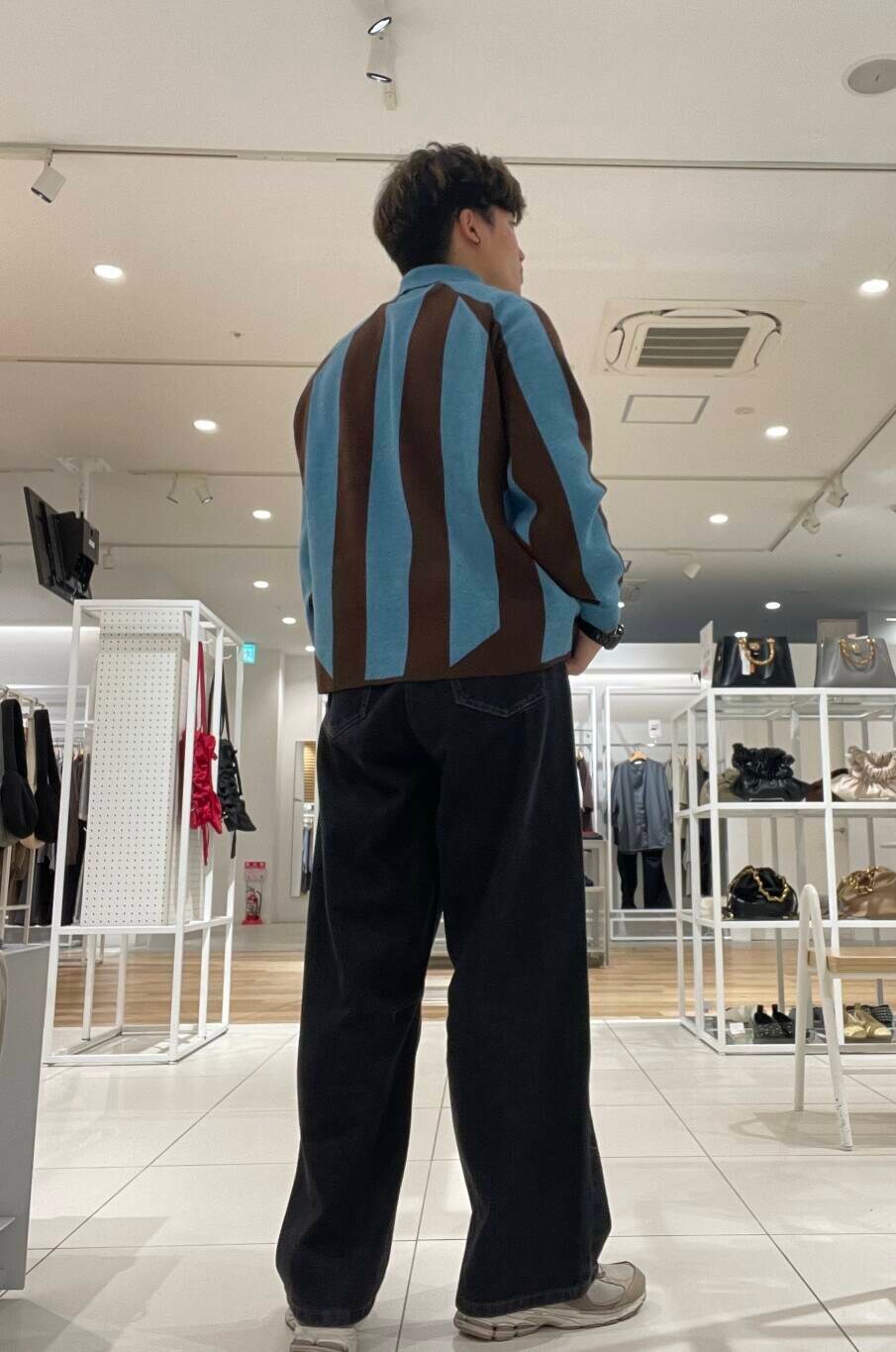 ブラック系のデニムパンツ、ブルー系のニット/セーターを着用したメンズの秋コーディネートの3枚目の写真