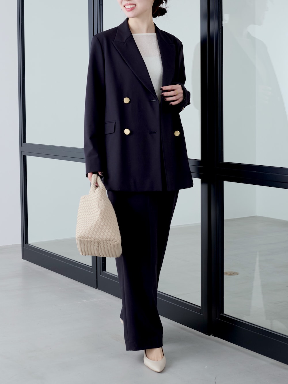 ブルー系のテーラードジャケット、ホワイト系のTシャツ/カットソー、ベージュ系のトートバッグを着用したレディースの冬コーディネートの4枚目の写真