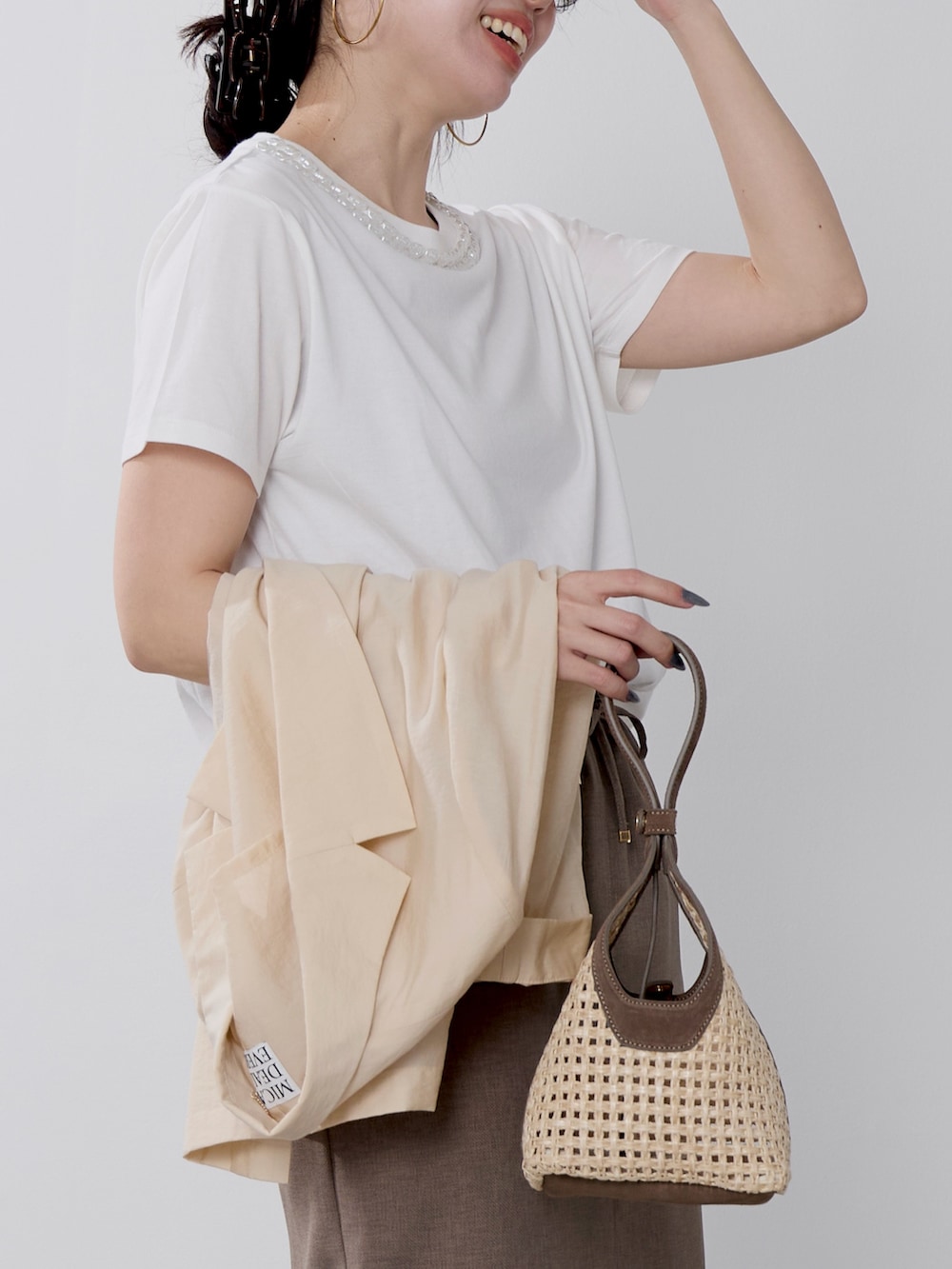ホワイト系のTシャツ/カットソー、ブラウン系のハンドバッグ、ベージュ系のテーラードジャケットを着用したレディースの春コーディネートの5枚目の写真