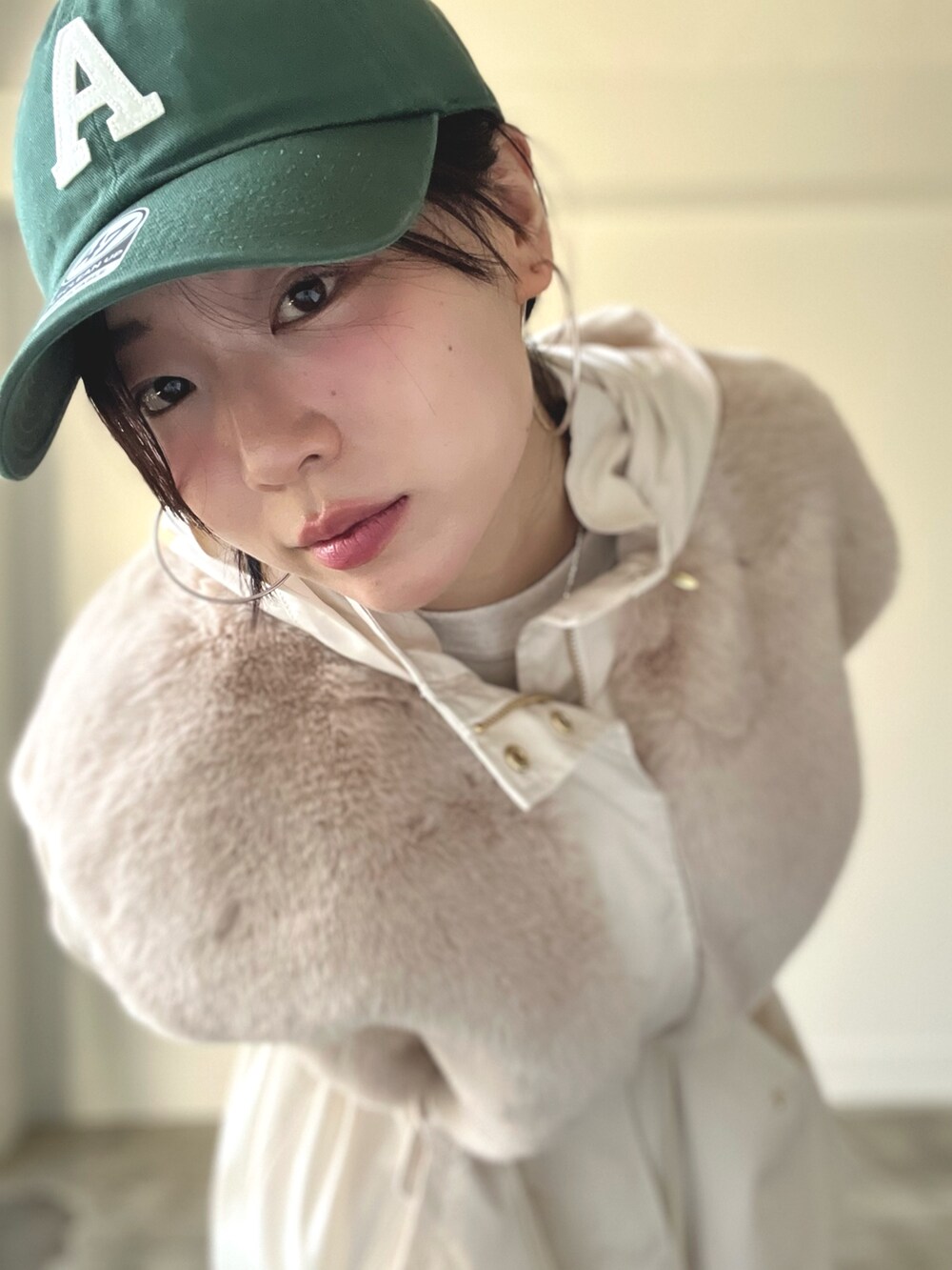 ベージュ系のブルゾン、ブルー系のデニムパンツ、グリーン系のキャップを着用したレディースの秋コーディネートの7枚目の写真