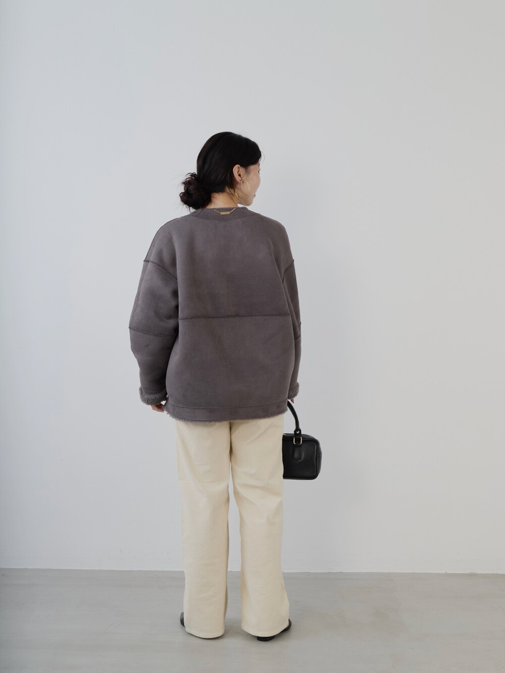 ブラック系のボストンバッグ、レッド系のニット/セーター、グレー系のノーカラーコートを着用したレディースの秋コーディネートの4枚目の写真