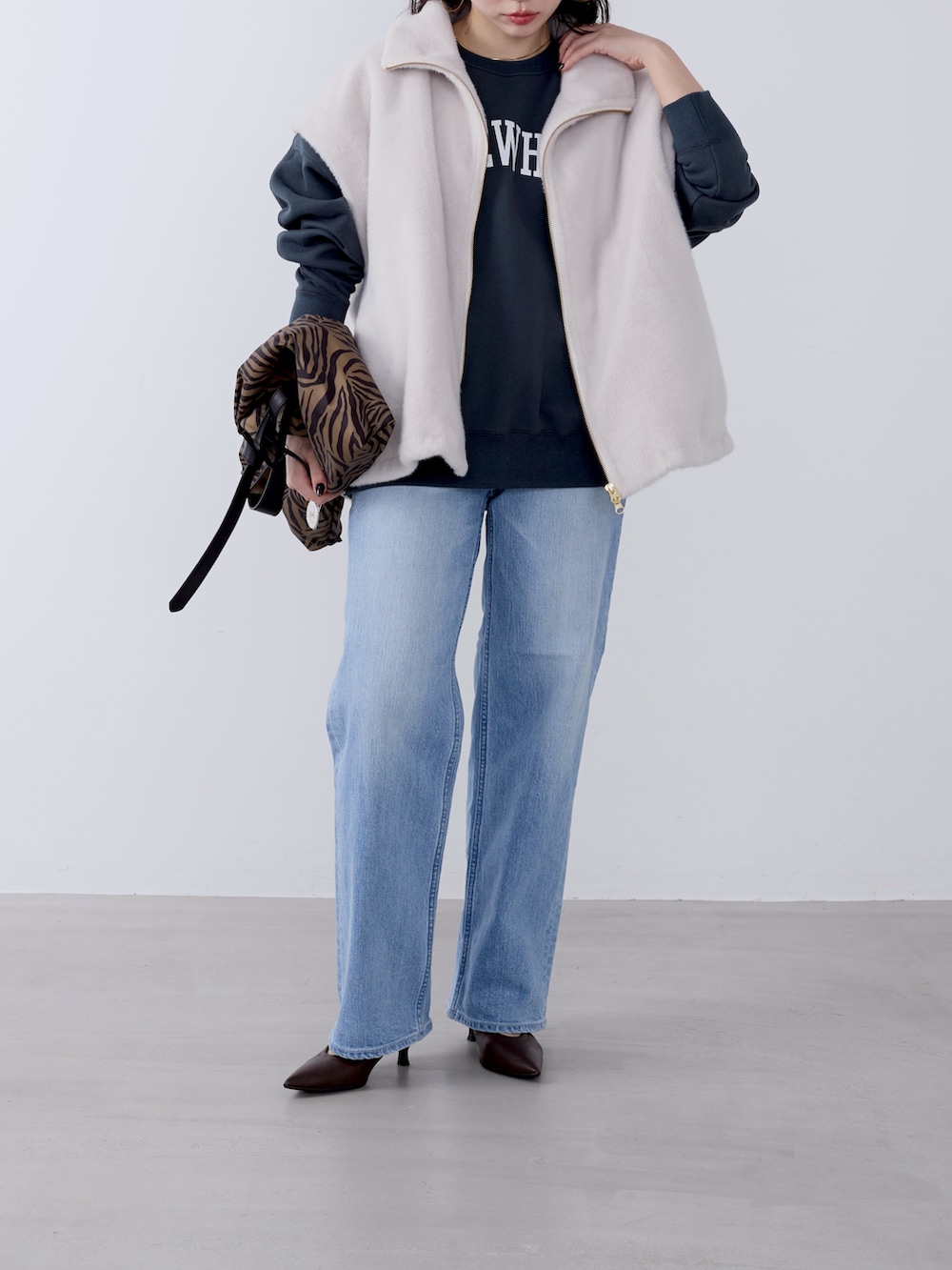 その他のトートバッグ、ブルー系のデニムパンツ、ホワイト系のその他アウターを着用したレディースの冬コーディネートの2枚目の写真