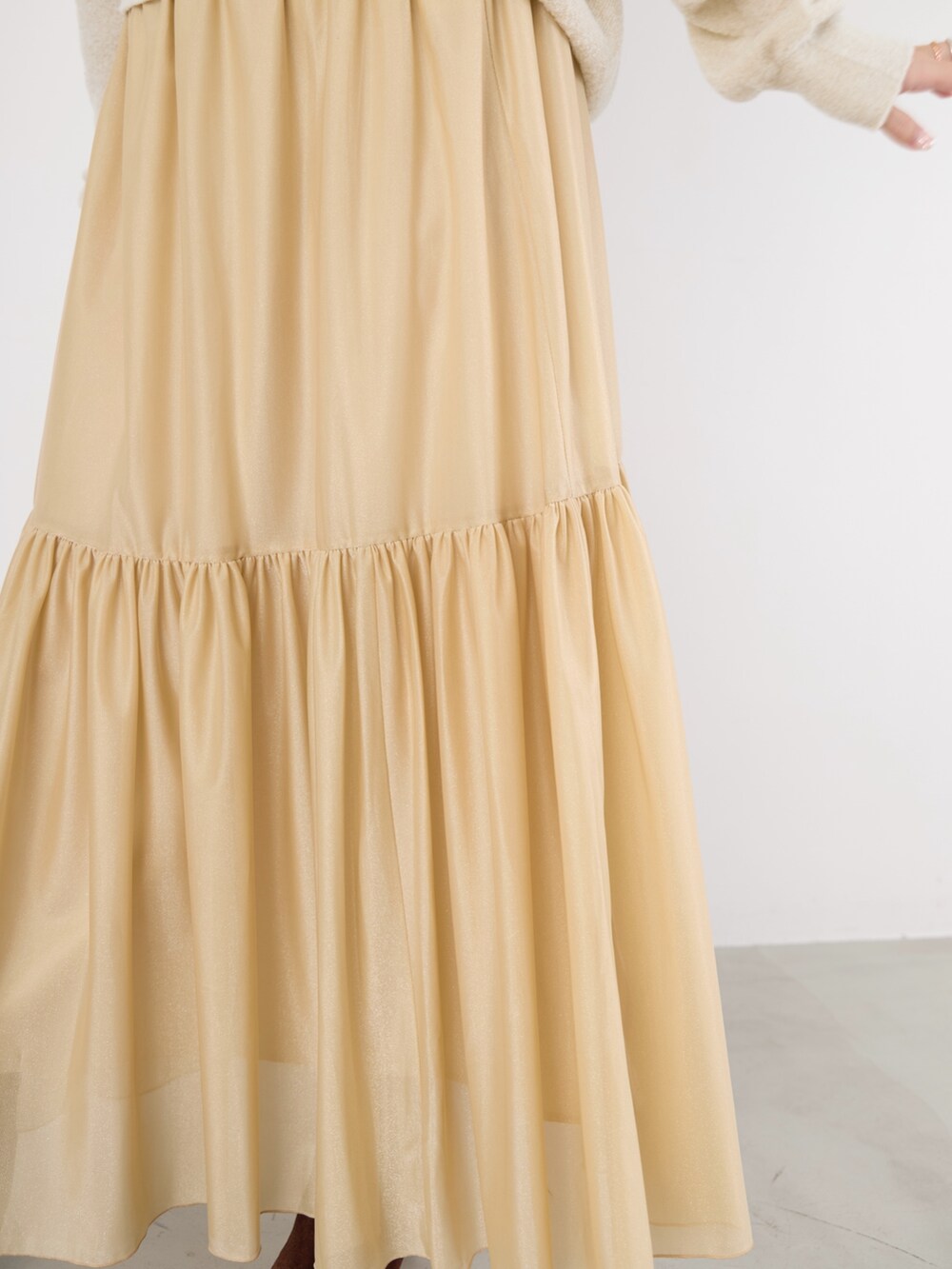 ホワイト系のニット/セーター、ベージュ系のスカート、ブラウン系のハンドバッグを着用したレディースの冬コーディネートの7枚目の写真