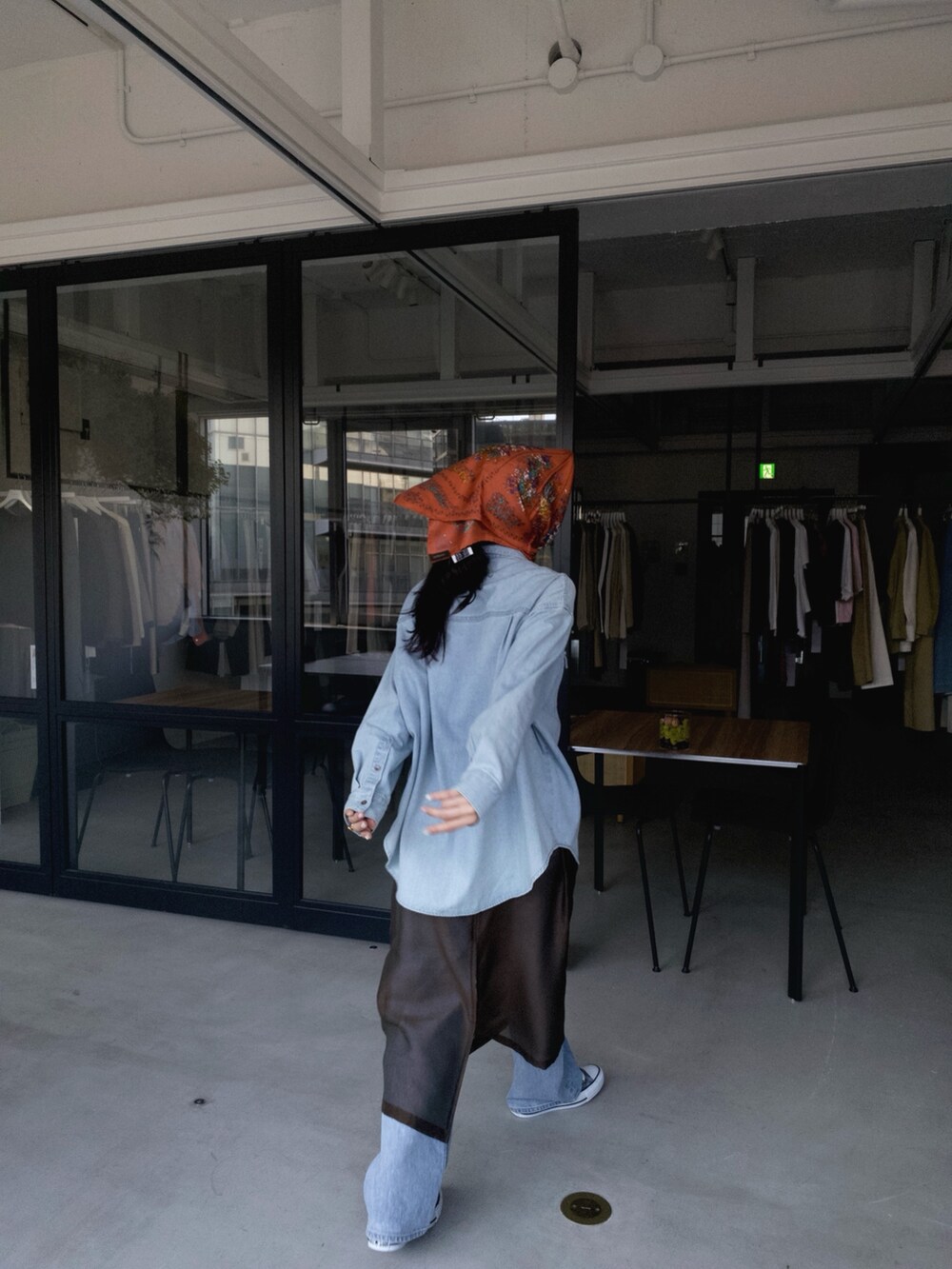 ブルー系のシャツ/ブラウス、ブラウン系のワンピース、ブルー系のデニムパンツを着用したレディースの夏コーディネートの2枚目の写真