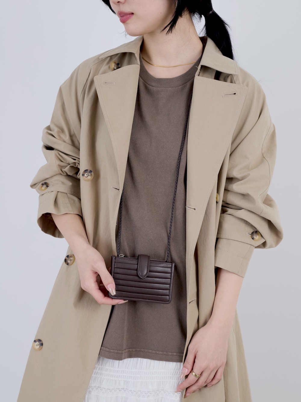 ベージュ系のトレンチコートを着用したレディースの冬コーディネートの4枚目の写真