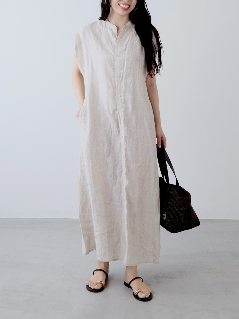 ベージュ系のワンピース、ブラウン系のトートバッグ、ブラウン系のサンダルを着用したレディースの夏コーディネートの2枚目の写真