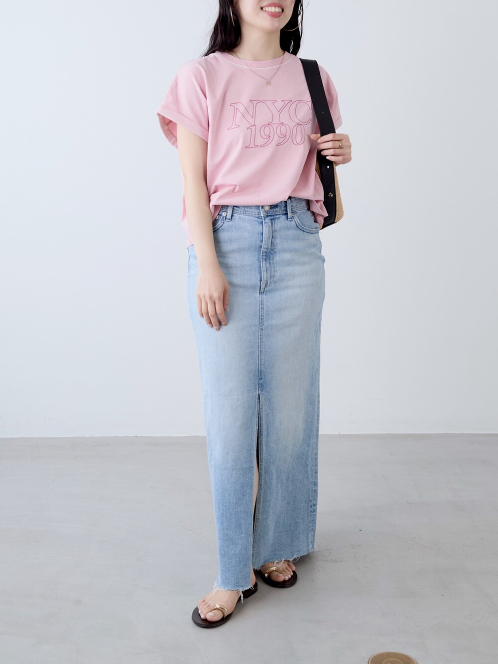 ピンク系のTシャツ/カットソー、ベージュ系のショルダーバッグ、ブルー系のスカートを着用したレディースの夏コーディネートの2枚目の写真