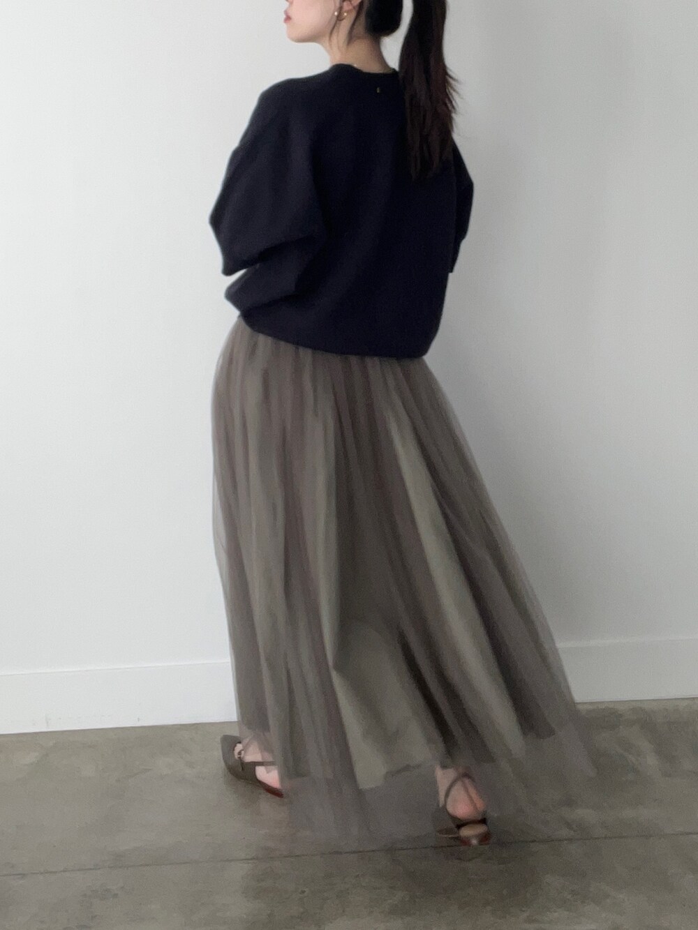 ブルー系のニット/セーター、グリーン系のスカートを着用したレディースの春コーディネートの2枚目の写真