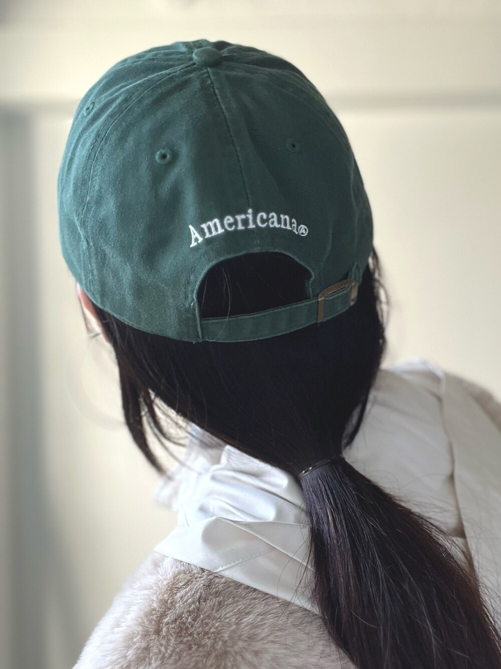 ベージュ系のブルゾン、ブルー系のデニムパンツ、グリーン系のキャップを着用したレディースの秋コーディネートの9枚目の写真