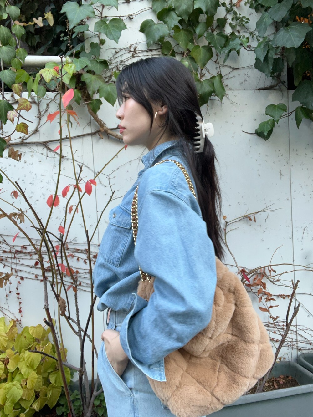 ベージュ系のショルダーバッグ、ブルー系のデニムパンツ、ブルー系のシャツ/ブラウスを着用したレディースの冬コーディネートの2枚目の写真