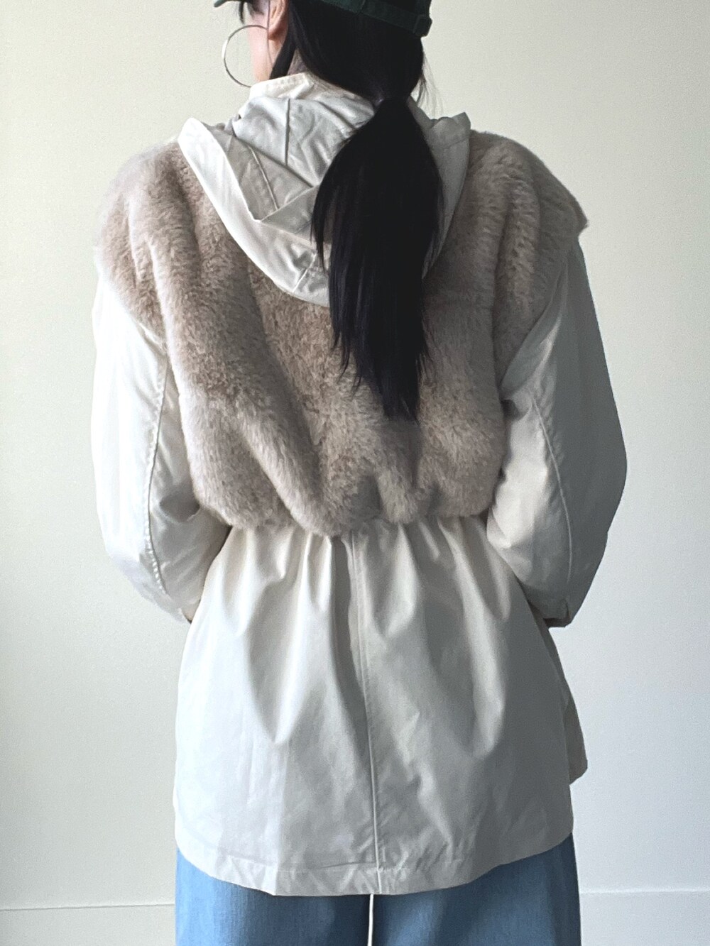 ベージュ系のブルゾン、ブルー系のデニムパンツ、グリーン系のキャップを着用したレディースの秋コーディネートの6枚目の写真