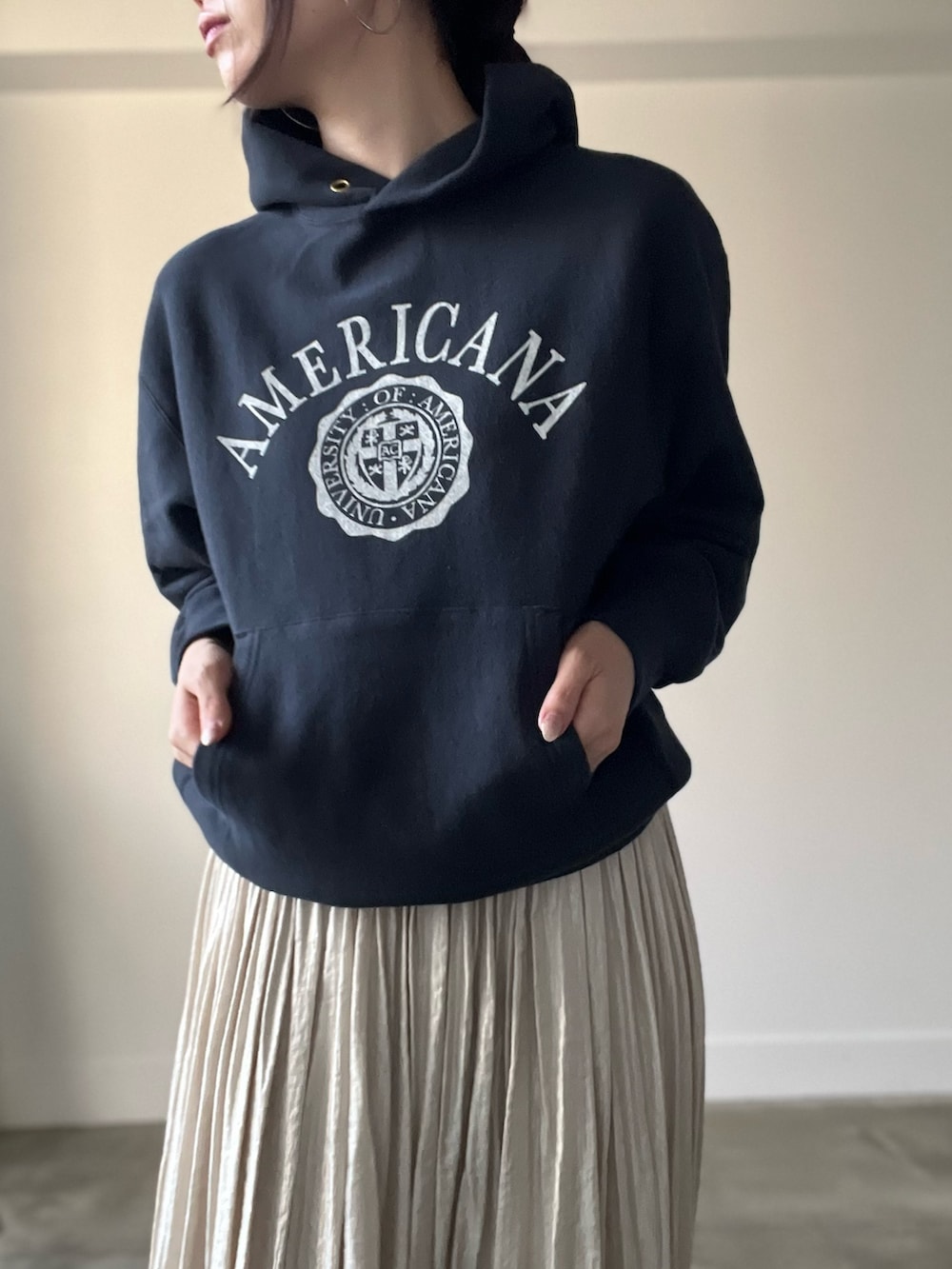 ブラック系のパーカー、ベージュ系のスカートを着用したレディースの秋コーディネートの6枚目の写真