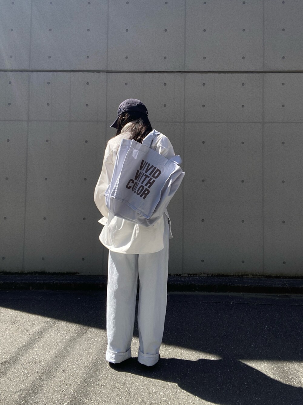 ホワイト系のシャツ/ブラウス、ホワイト系のトートバッグ、ブルー系のデニムパンツを着用したレディースの春コーディネートの4枚目の写真