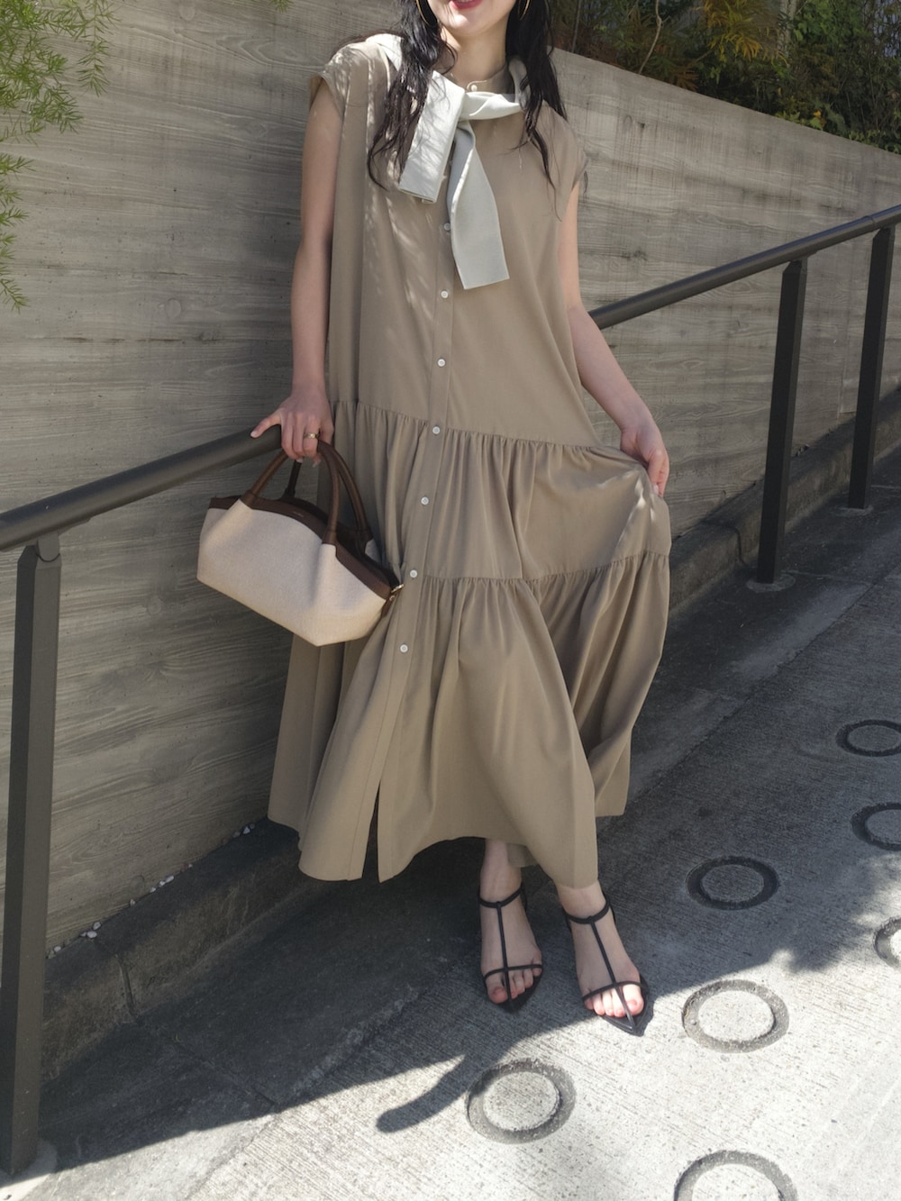 ベージュ系のワンピース、ブラウン系のトートバッグ、ベージュ系のニット/セーターを着用したレディースの春コーディネートの2枚目の写真