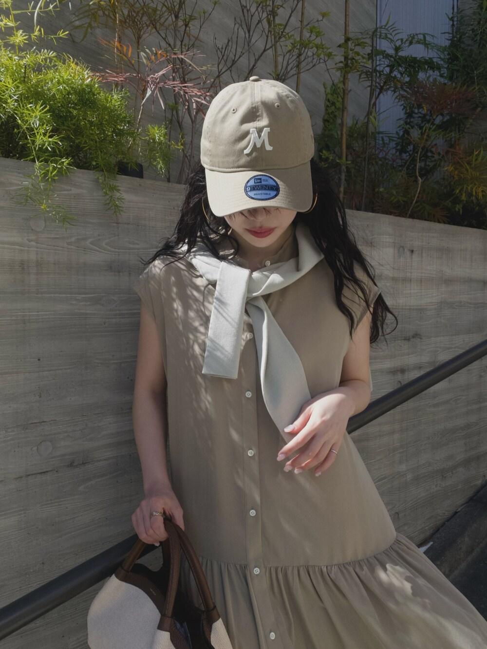 ベージュ系のワンピース、ブラウン系のトートバッグ、ベージュ系のニット/セーターを着用したレディースの春コーディネートの3枚目の写真