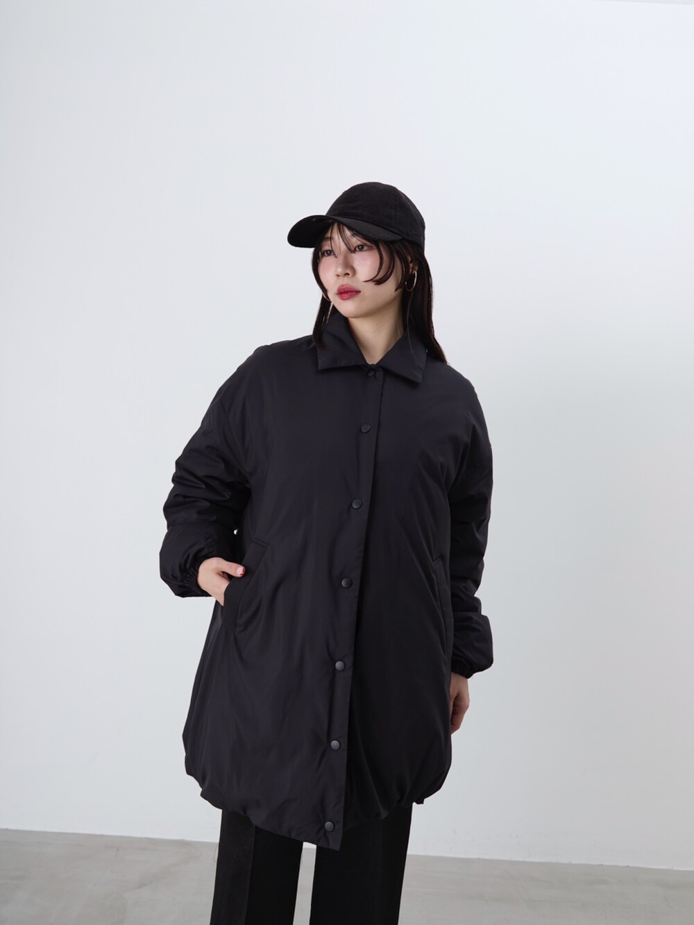 ブラック系のその他パンツ、ブラック系のダウンジャケット/コート、ブラウン系のニット/セーターを着用したレディースの冬コーディネートの10枚目の写真