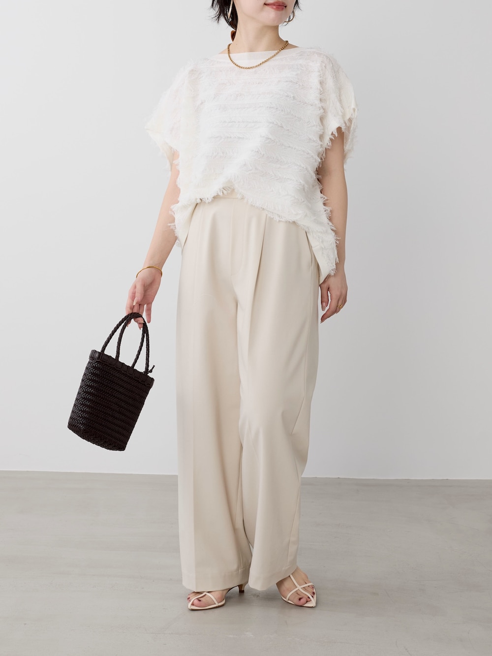 ベージュ系のその他パンツ、ホワイト系のニット/セーターを着用したレディースの春コーディネートの3枚目の写真