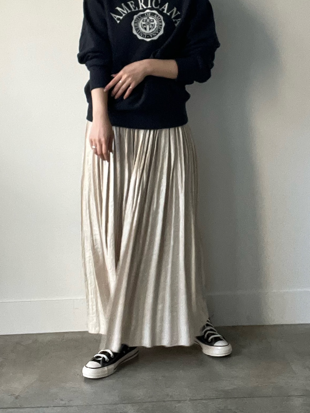 ブラック系のパーカー、ベージュ系のスカートを着用したレディースの秋コーディネートの3枚目の写真