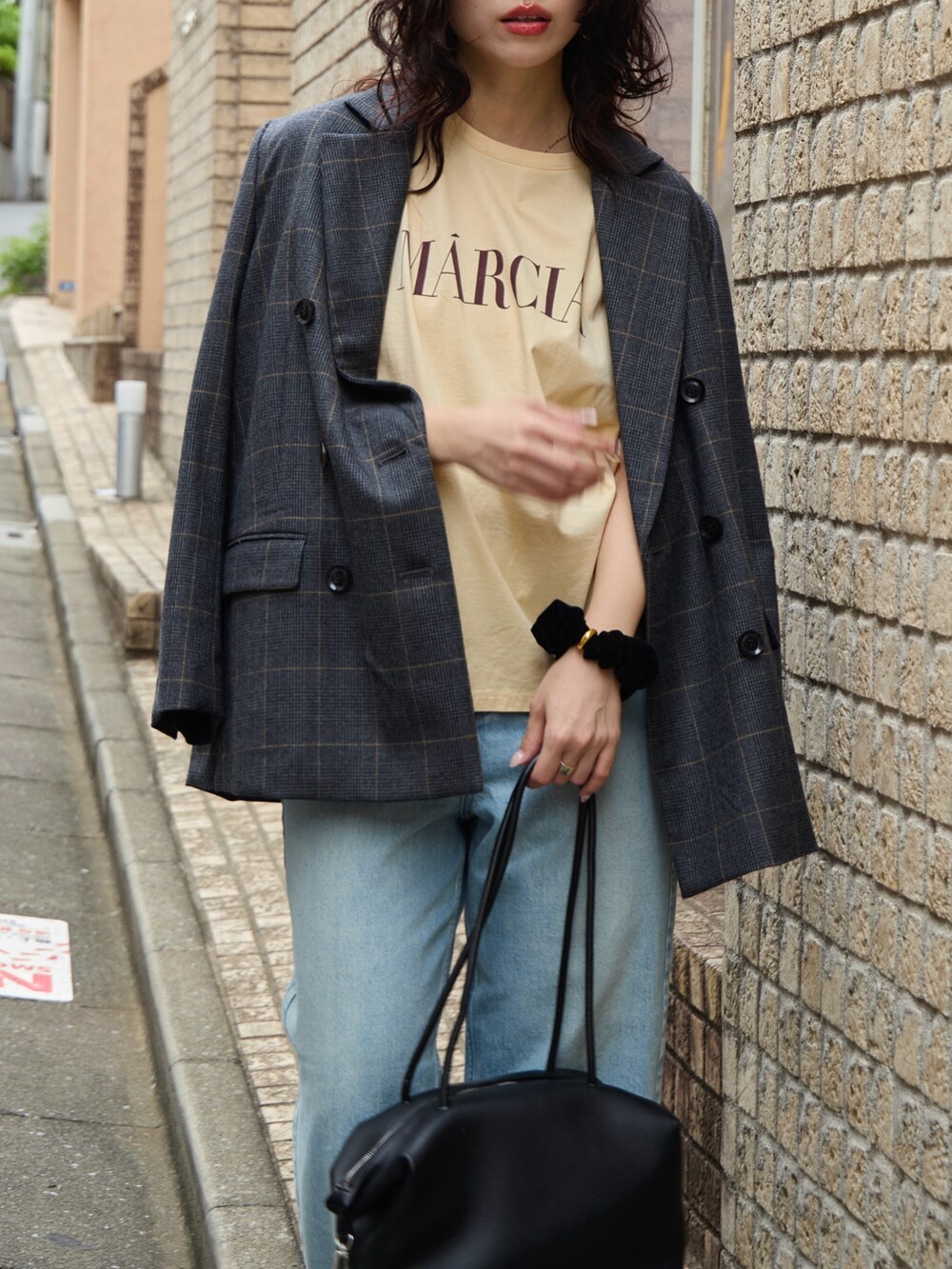 グレー系のテーラードジャケット、オレンジ系のTシャツ/カットソー、ブラック系のボストンバッグを着用したレディースの秋コーディネートの2枚目の写真