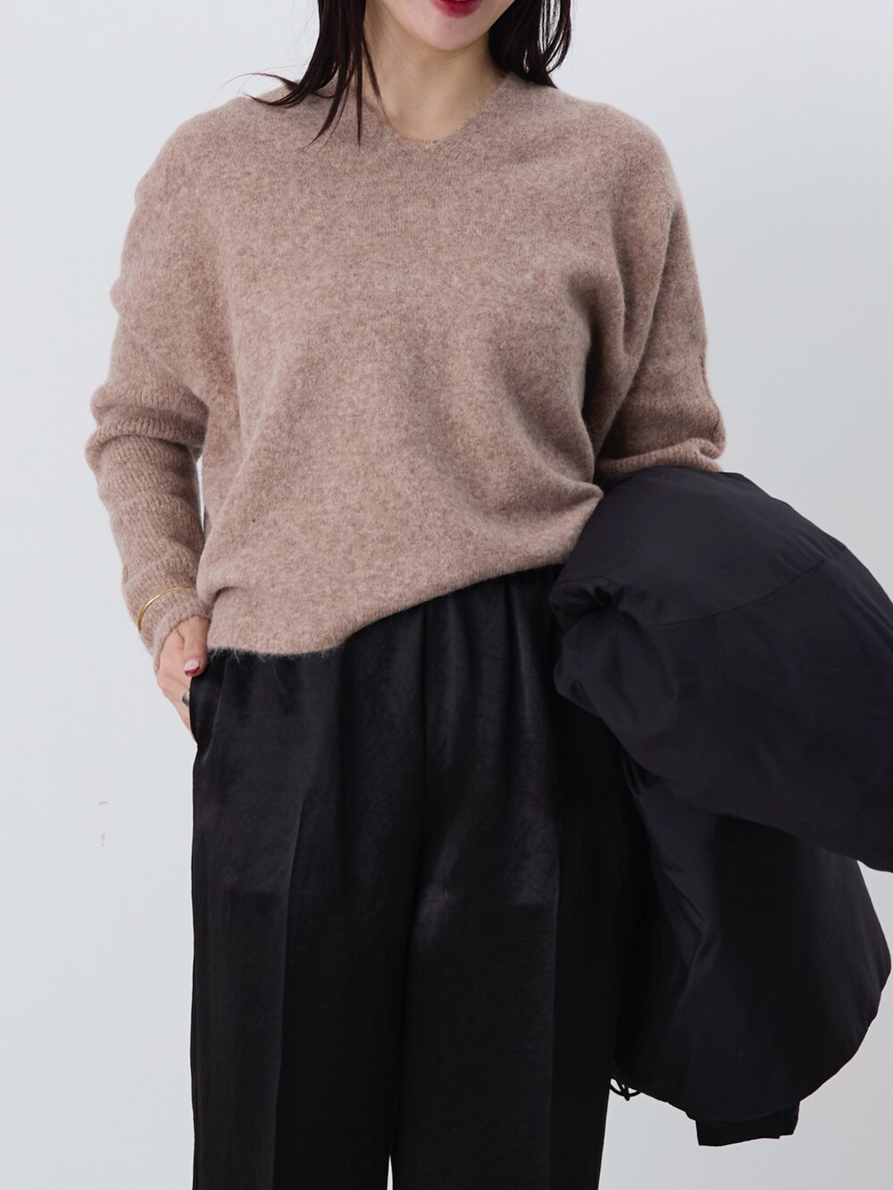 ブラック系のその他パンツ、ブラック系のダウンジャケット/コート、ブラウン系のニット/セーターを着用したレディースの冬コーディネートの6枚目の写真